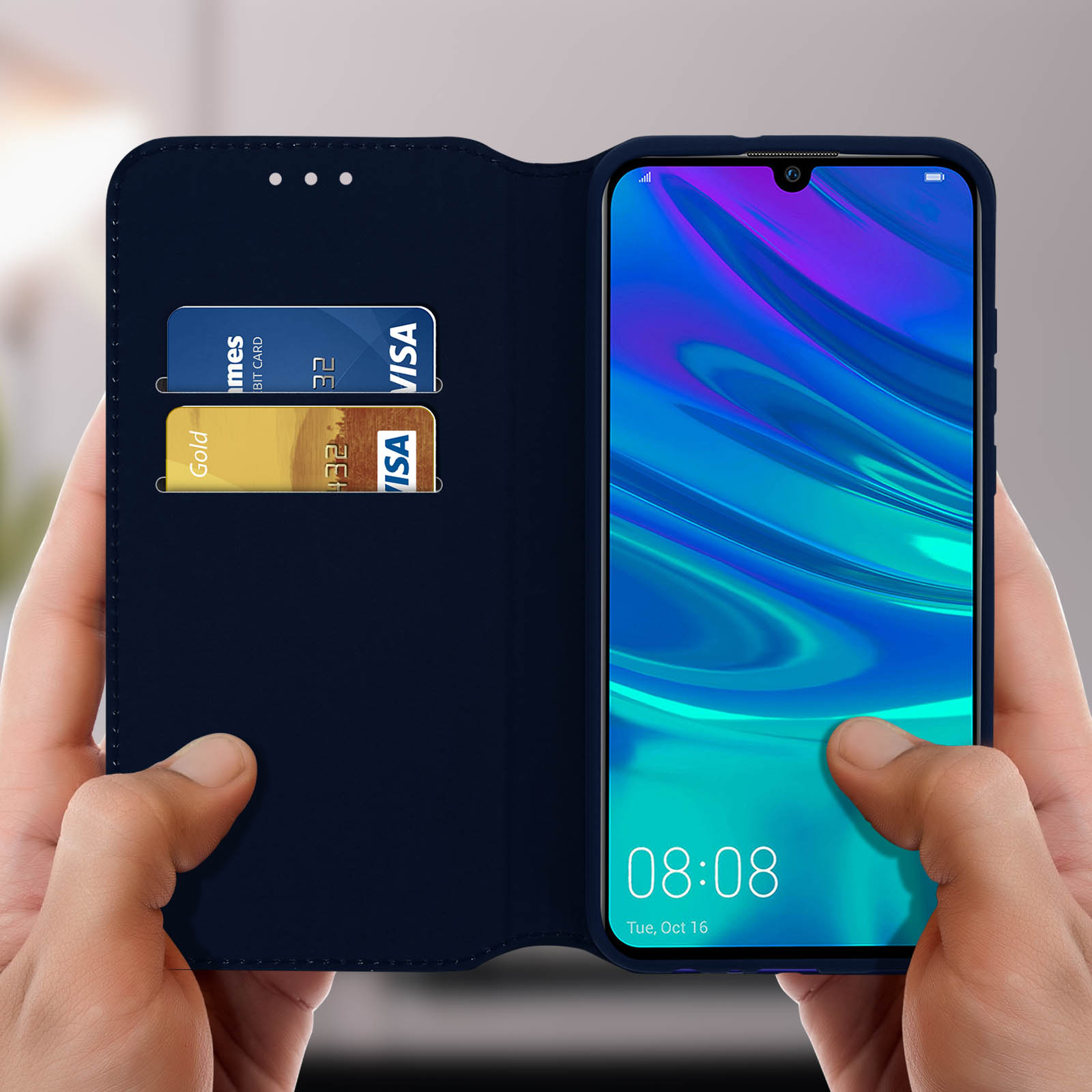 Mani che tengono una custodia blu scuro con due carte di credito e schermo del telefono.