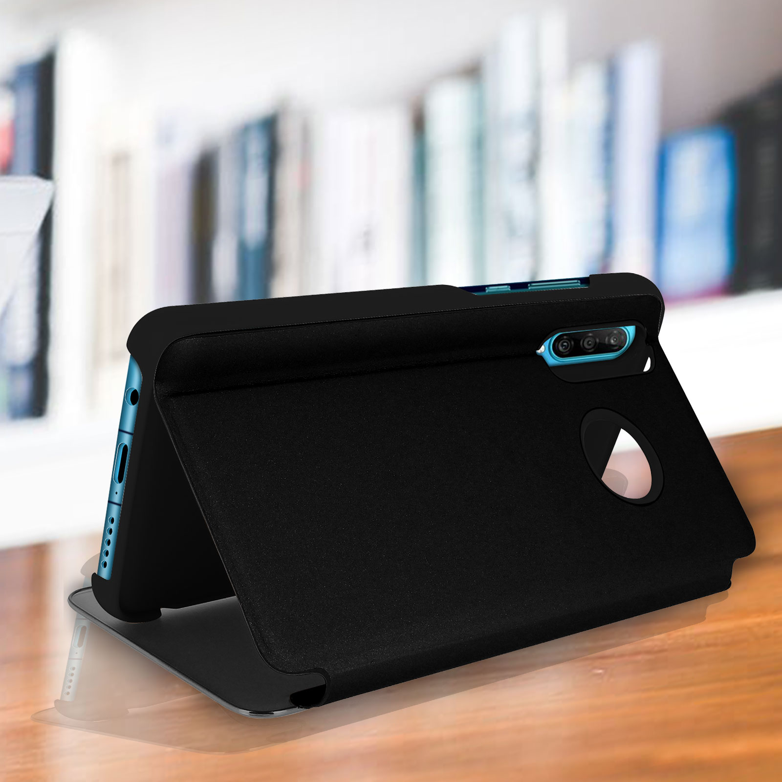 Custodia nera per telefono, aperta, appoggiata su una superficie in legno. Sfondo: libri sfocati.