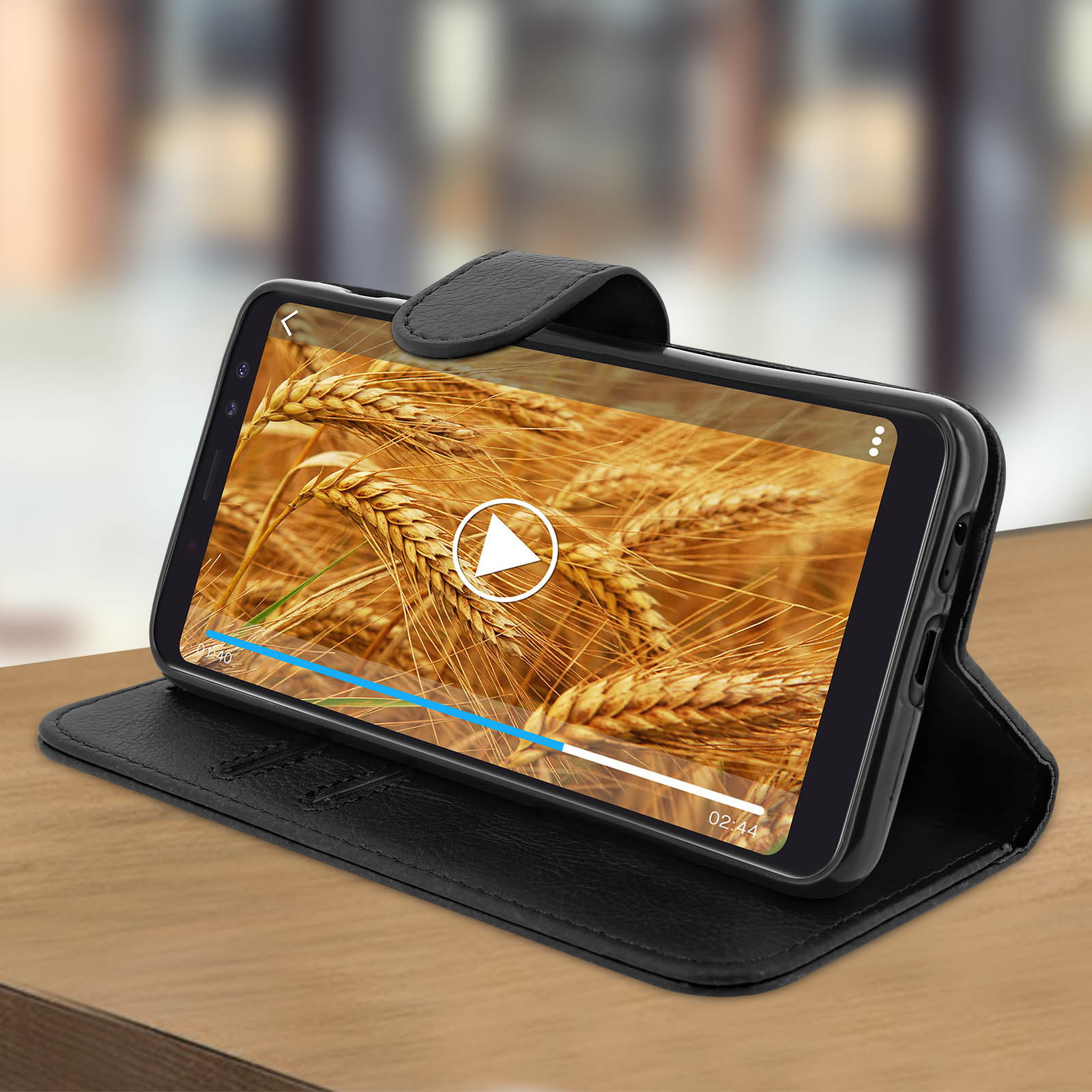 Telefono nero in una custodia in pelle nera, aperto con un video in riproduzione.