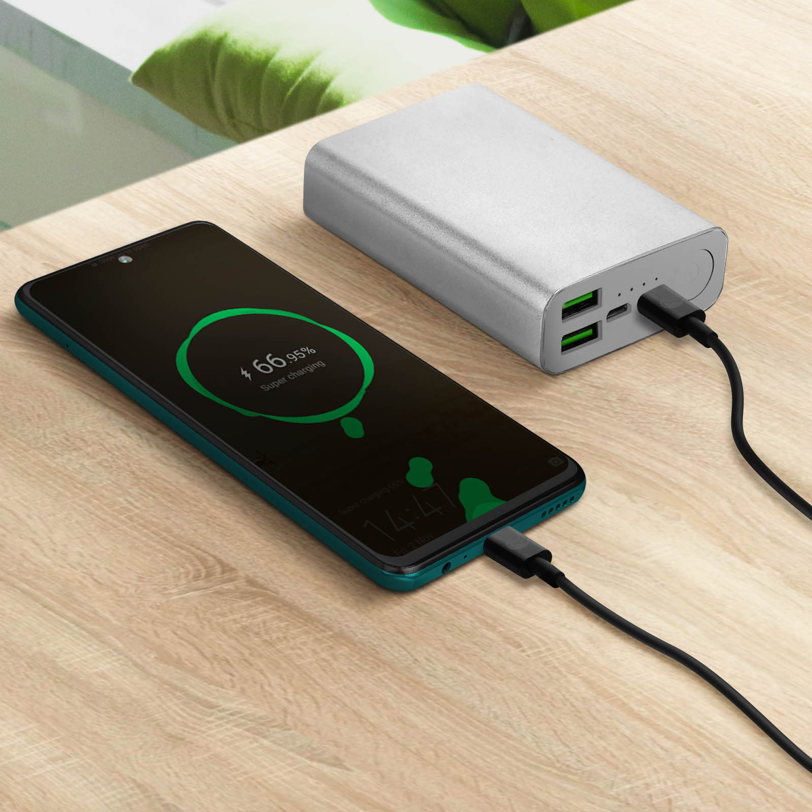 Telefono in carica, mostra 66,95% batteria. Power bank a destra, collegato con cavo nero.