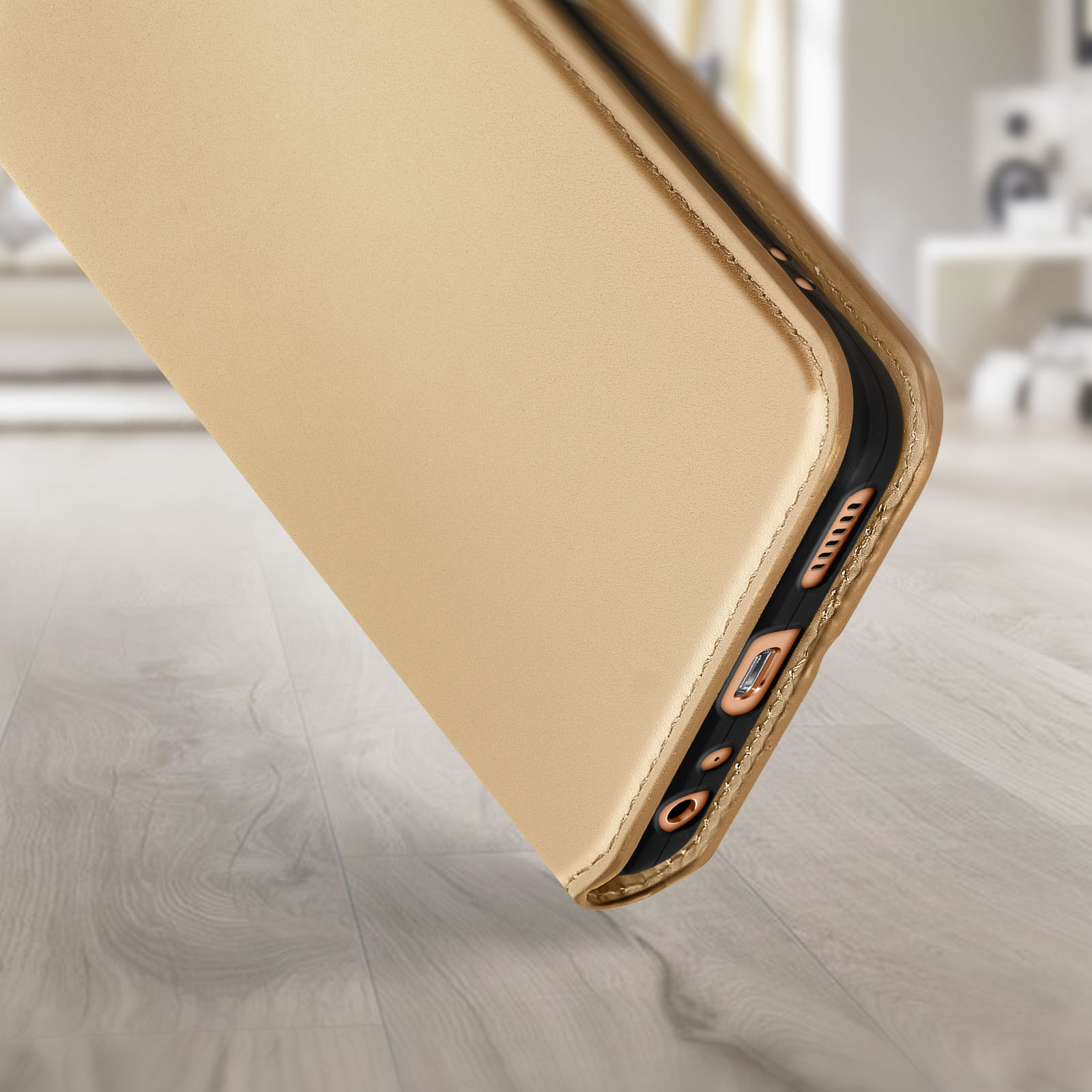 Gouden telefoonhoes. Een telefoonhoes ligt op een houten oppervlak. De hoes is goud.