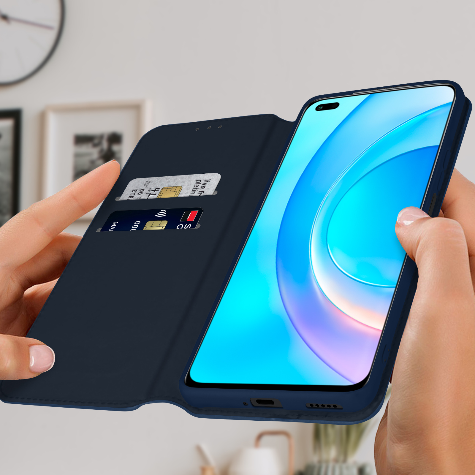 Une main tient un téléphone dans un étui bleu. L'étui est ouvert, montrant des cartes de crédit et l'écran.