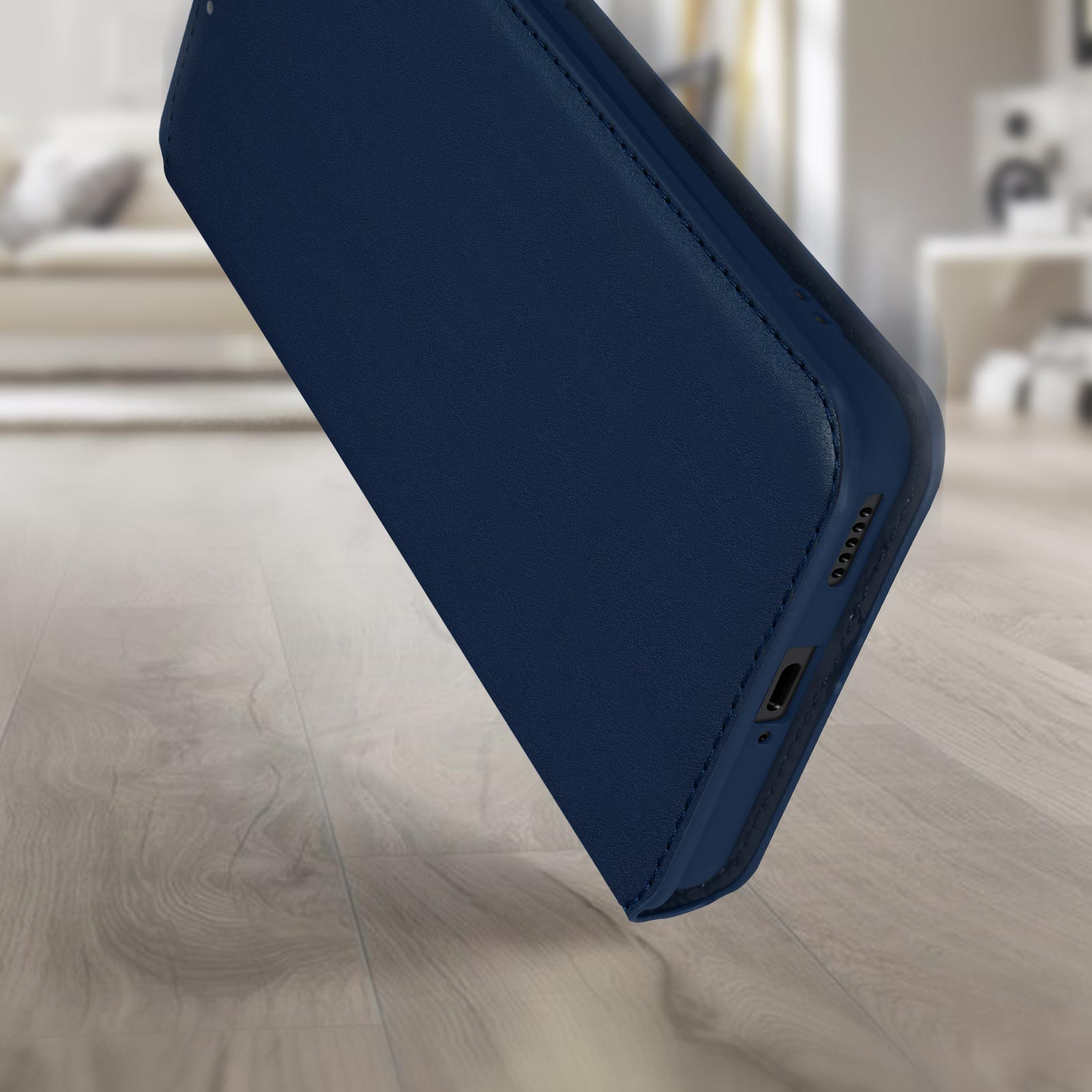 Un étui de téléphone bleu marine, incliné, montrant la partie inférieure. Fond en bois.