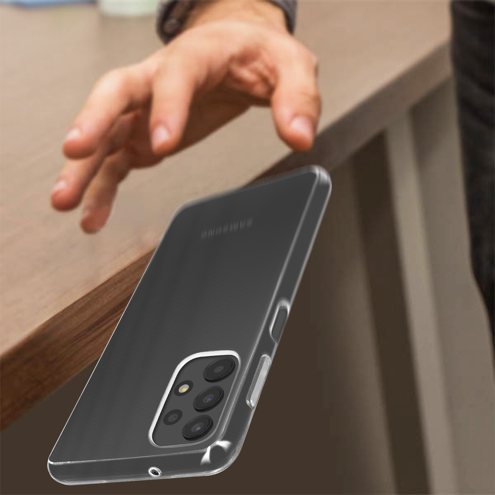 Mano che raggiunge un telefono in una custodia trasparente. Appoggiato su una superficie di legno.