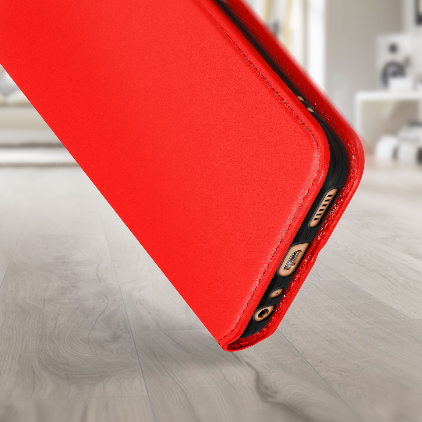 Rode telefoonhoes schuin, de onderkant tonend. Houten oppervlak, wazige achtergrond.