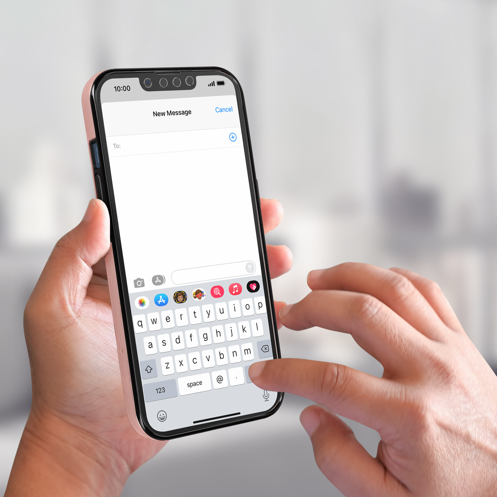 Une personne tenant un smartphone avec une coque rose et un message texte ouvert, un arrière-plan flou est visible.