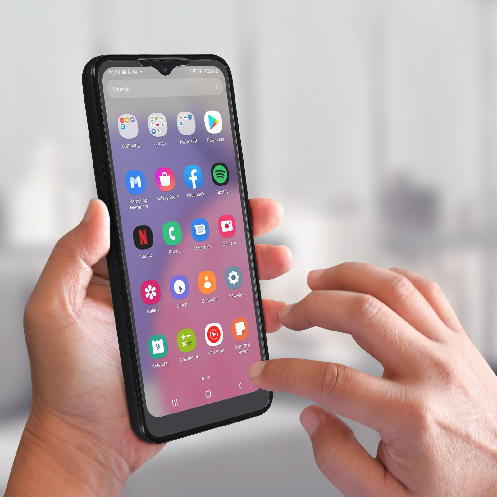 Mani che tengono uno smartphone nero con app visibili sullo schermo.
