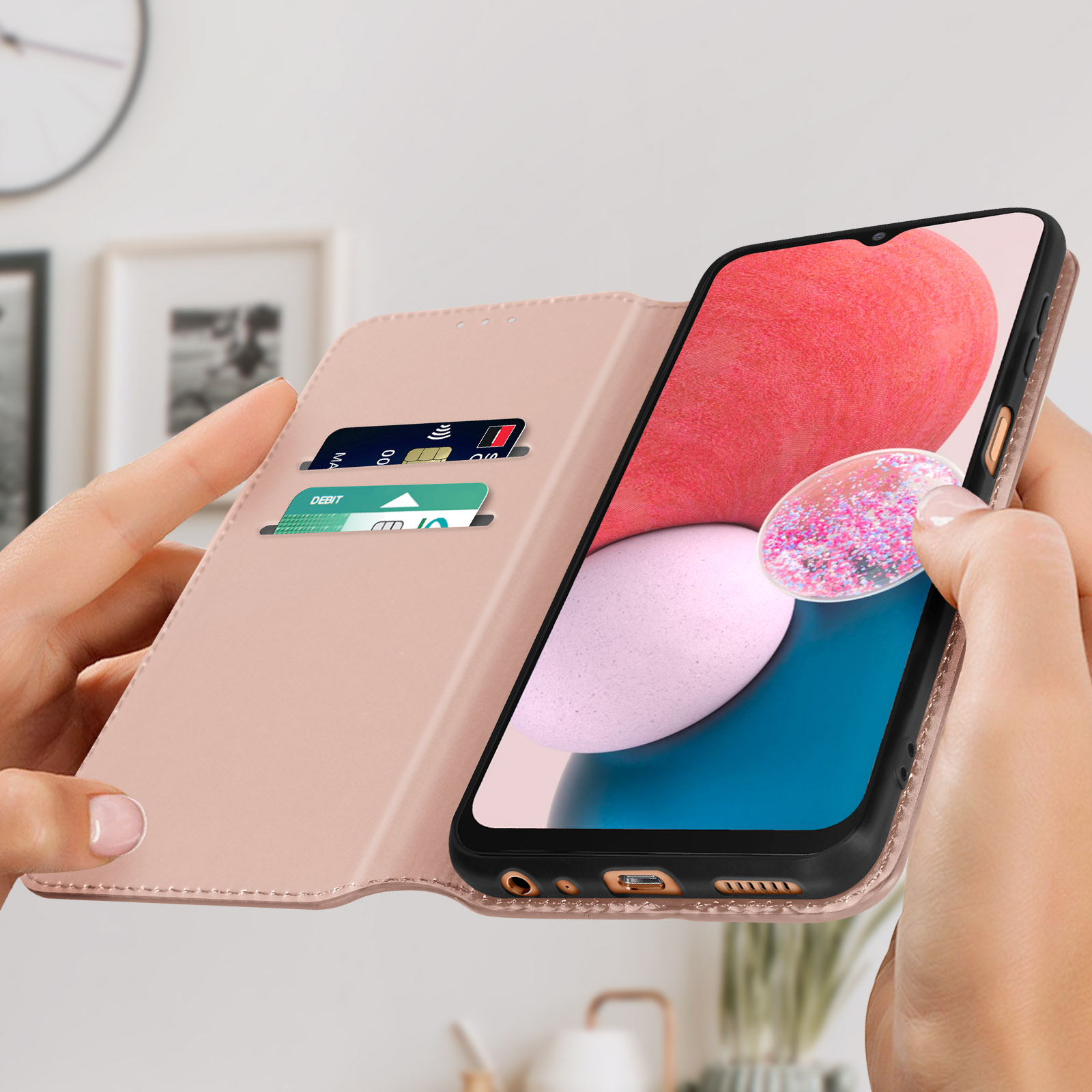 Handen die een roze telefoonhoes openhouden, met kaarten erin. Telefoonscherm toont een afbeelding met roze achtergrond.