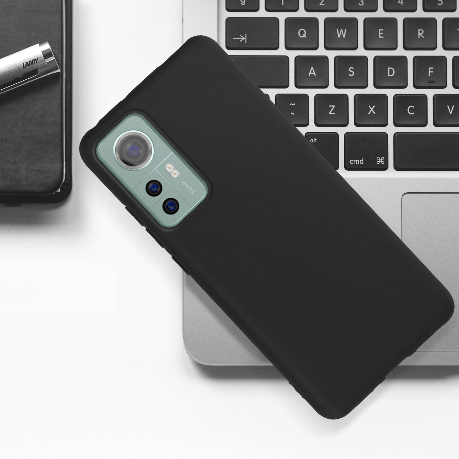 Una custodia per telefono nera con una sezione fotocamera argentata su una tastiera del laptop.