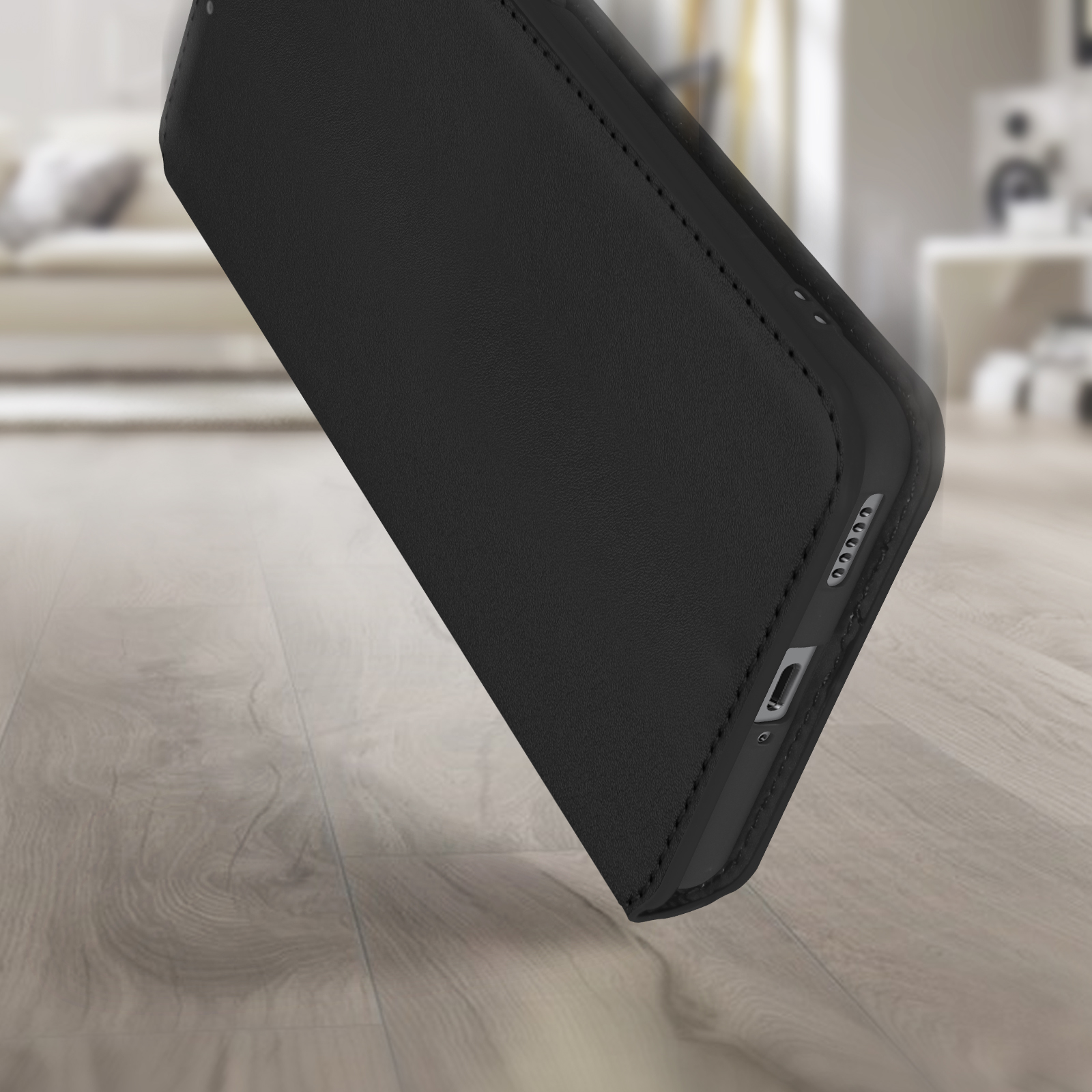 Gros plan d'une coque noire sur un sol en bois, montrant boutons et port de charge.