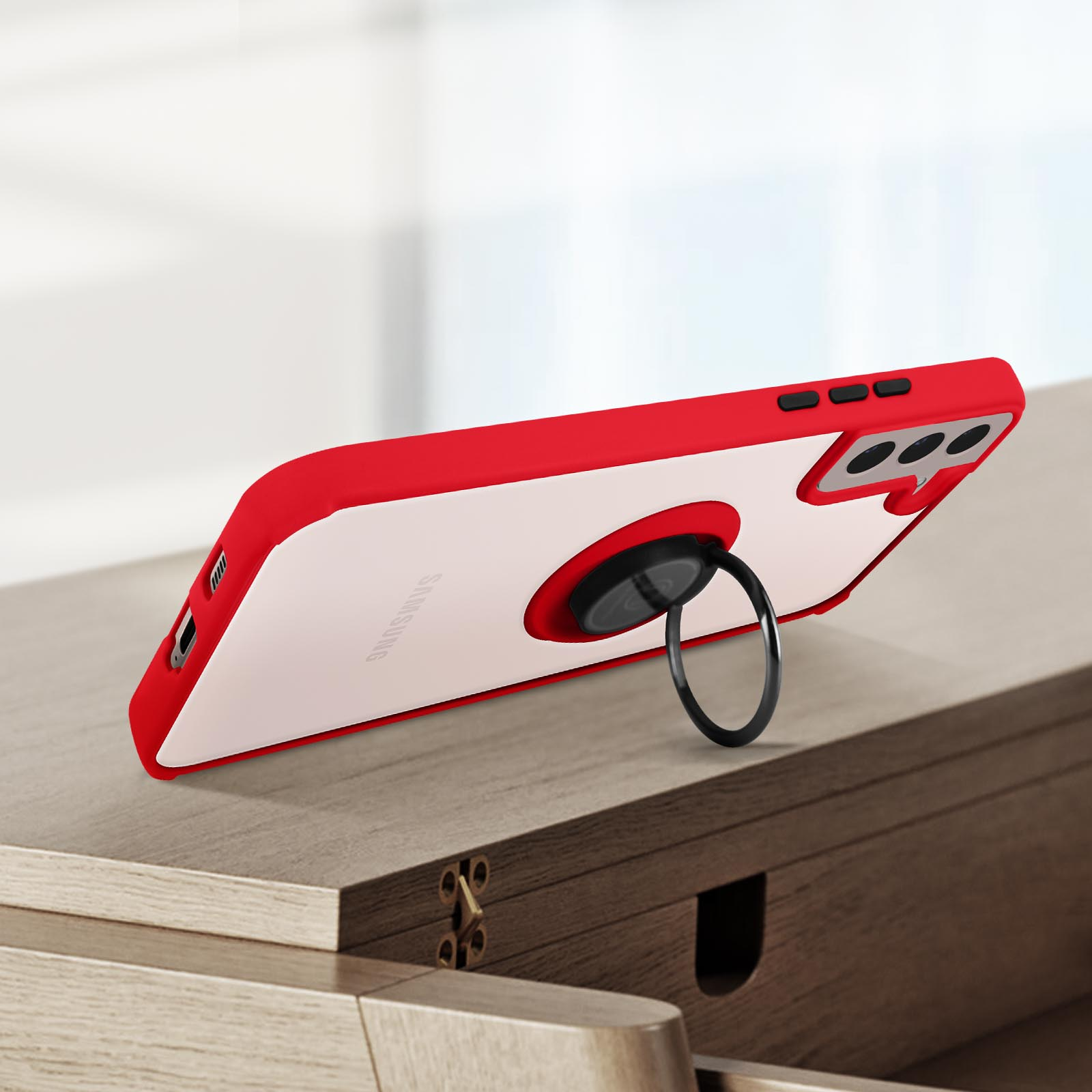 Coque de téléphone rouge avec support annulaire sur une surface en bois. Coque claire et blanche.