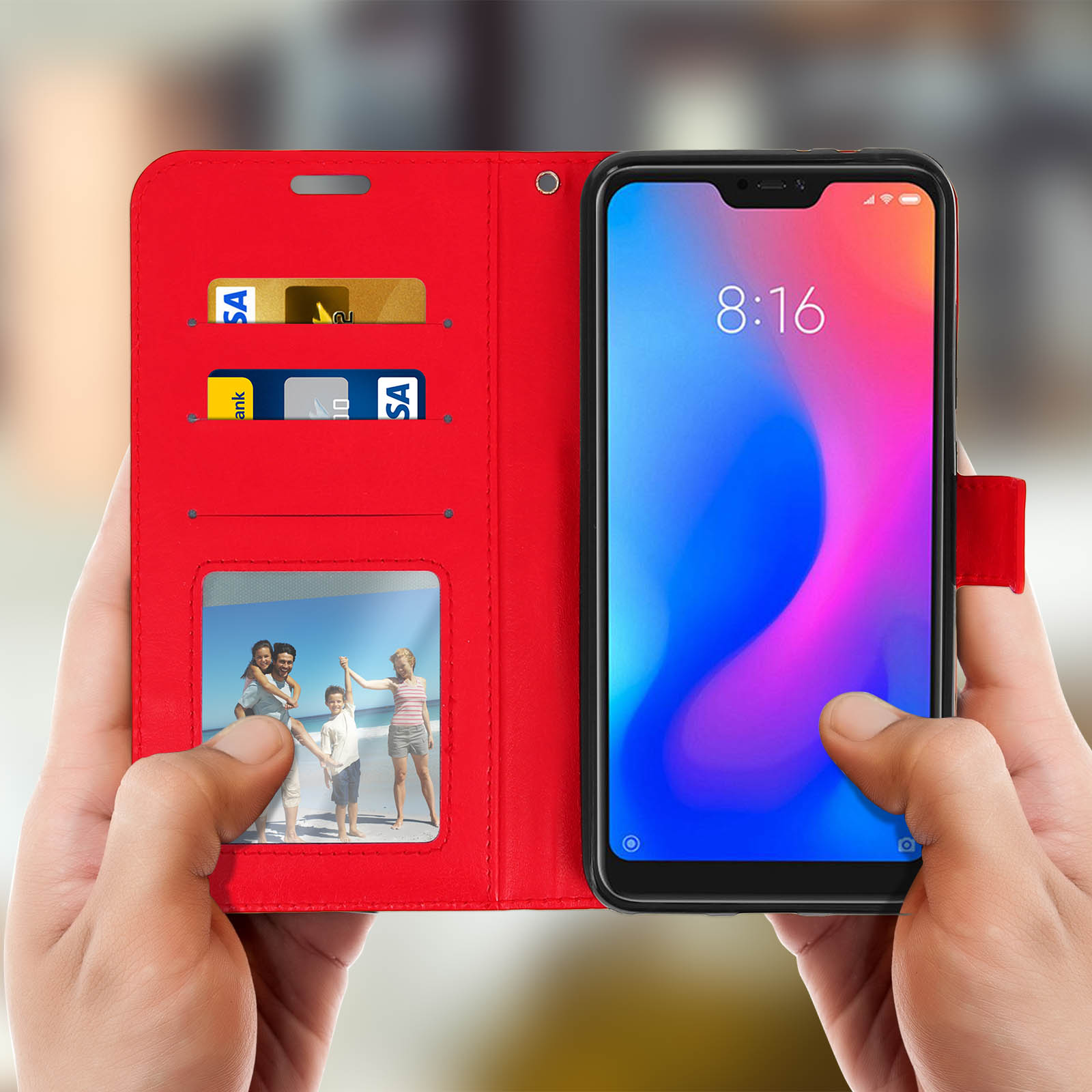 Mani che tengono una custodia rossa con carte e foto di famiglia all'interno.