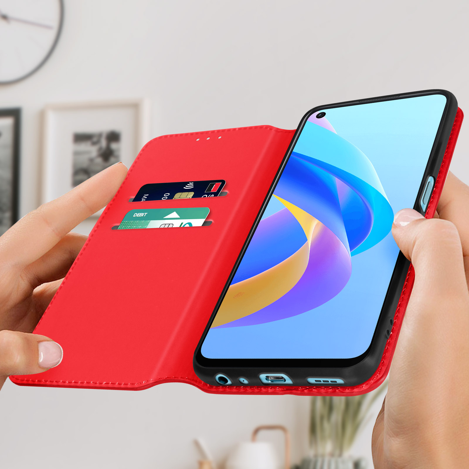 Étui de téléphone rouge, ouvert, avec téléphone et cartes. Mains tenant l'étui.
