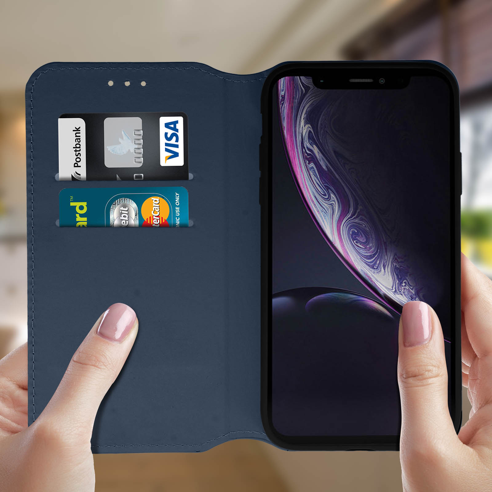 Una custodia blu con carte, un telefono è dentro. Le mani tengono la custodia. Sfuocato.
