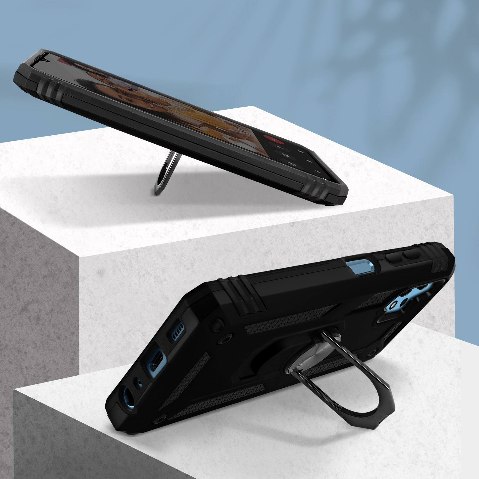 Téléphone noir dans un étui avec support d'anneau, sur une plateforme blanche et fond bleu.
