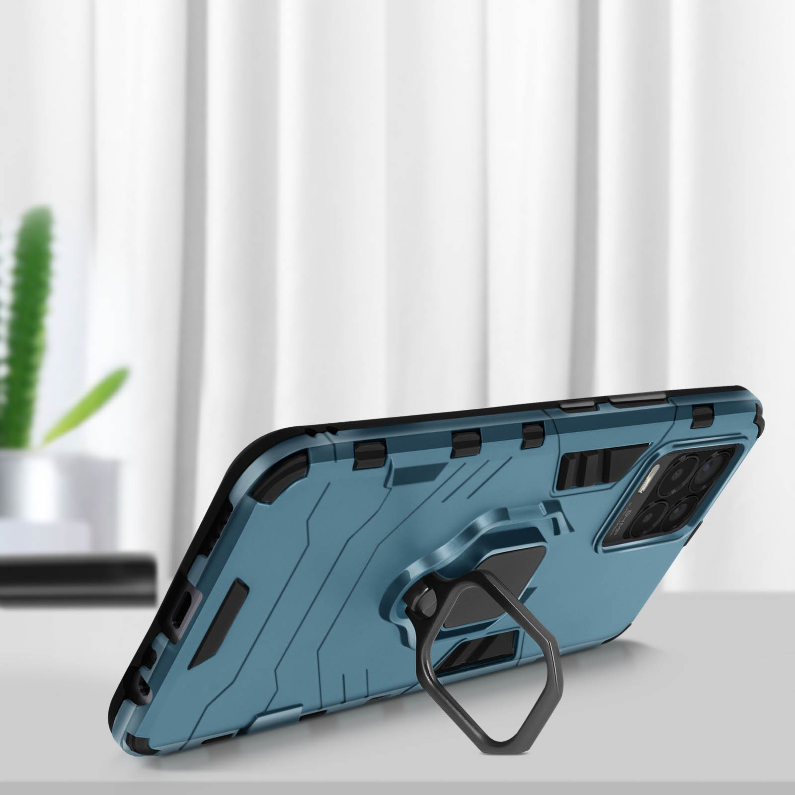 Custodia blu per telefono con supporto su un tavolo bianco. Sfondo sfocato visibile.