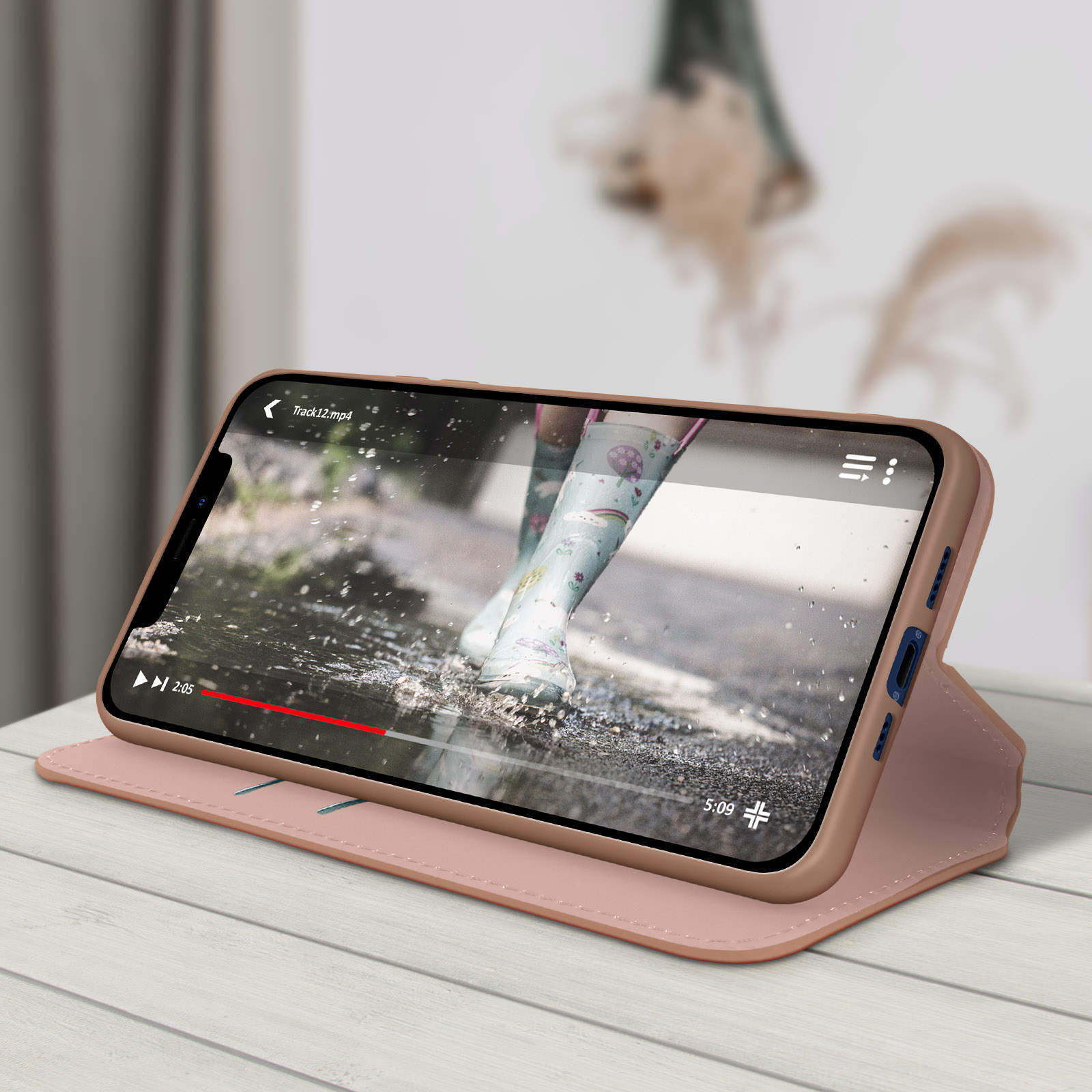 Een telefoon toont een video van laarzen in water. De telefoon zit in een roze hoes.