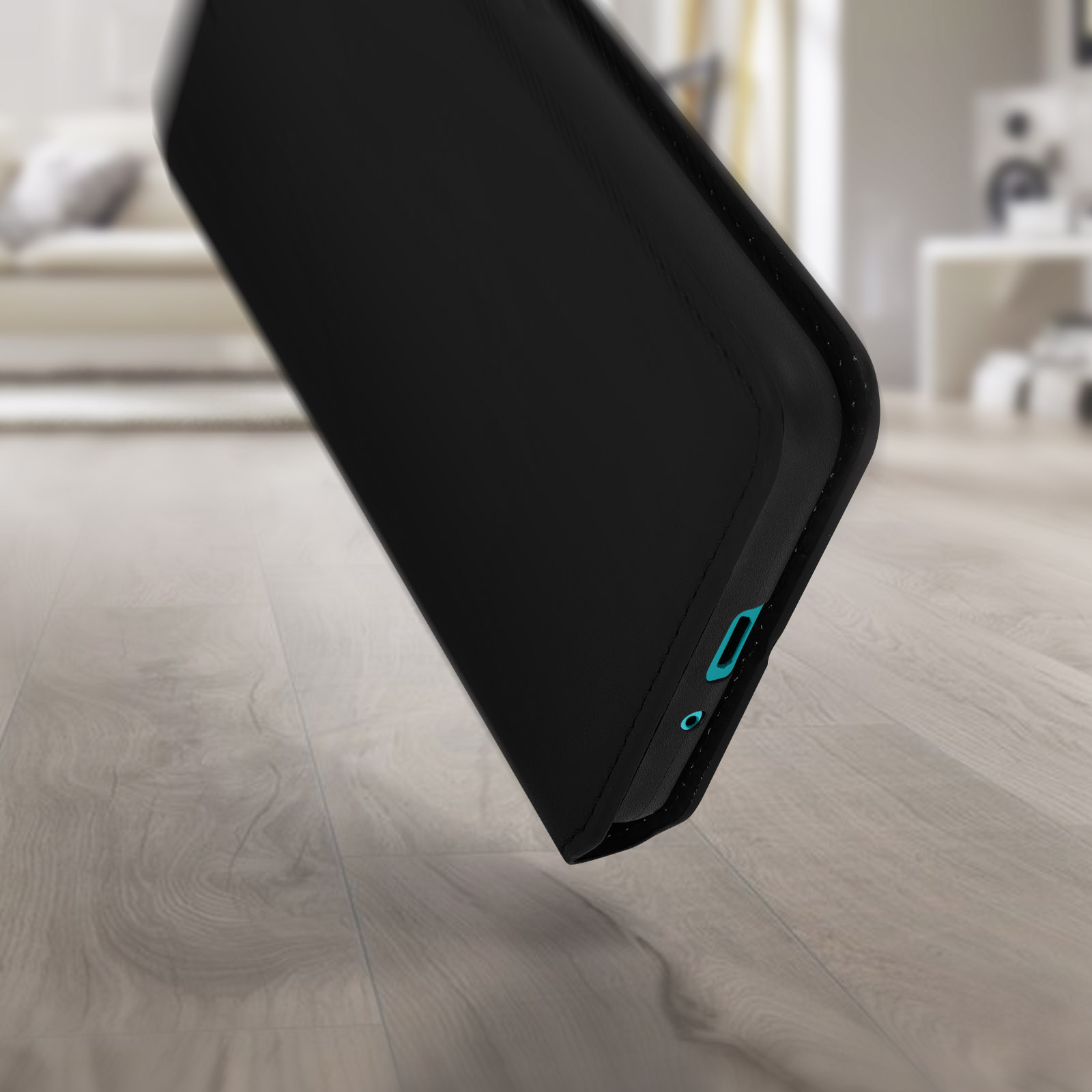 Custodia per telefono nera angolata, che mostra la parte inferiore. Dettagli turchese. Superficie in legno, sfondo sfocato.