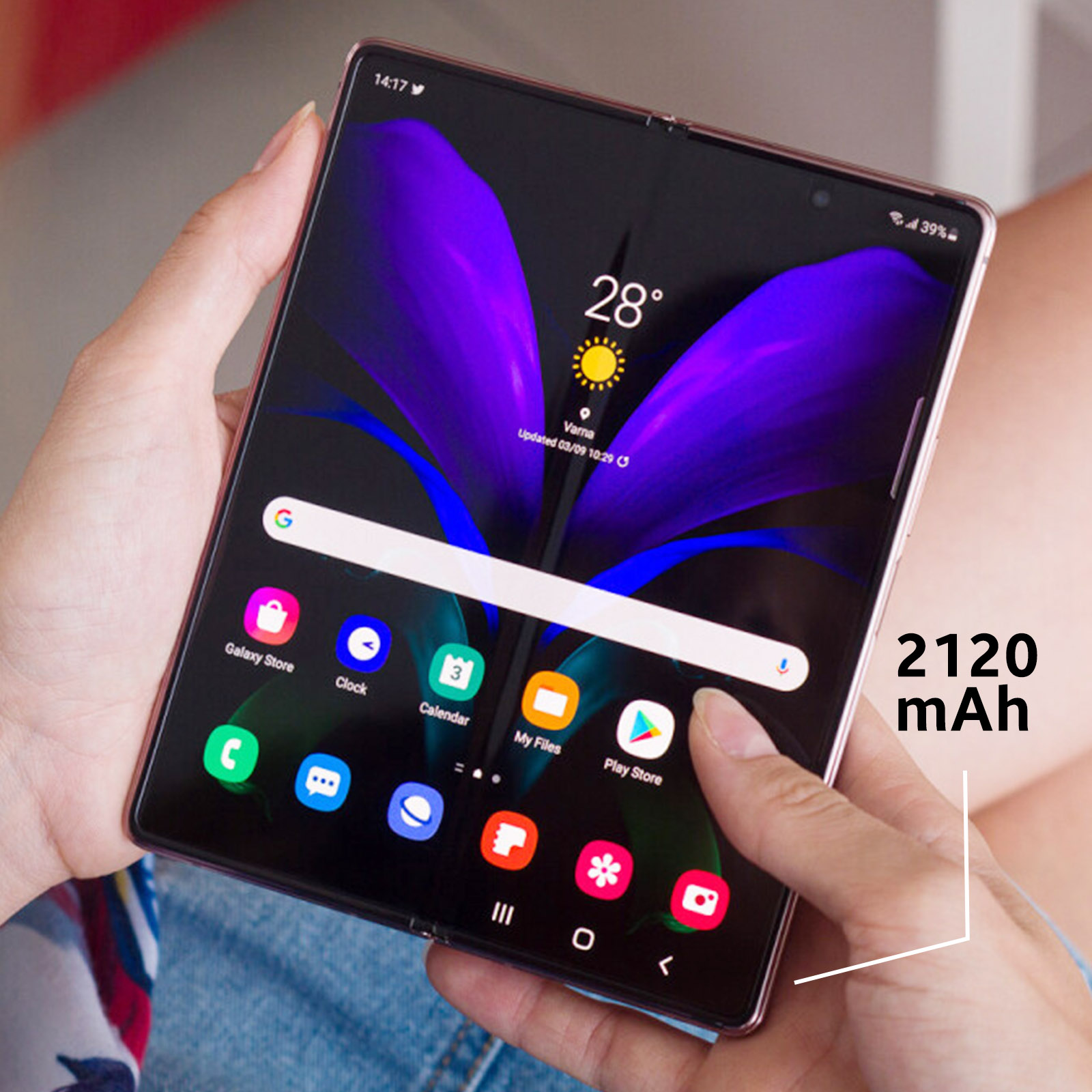 Persona sosteniendo teléfono plegado mostrando pantalla de inicio e iconos de aplicaciones.