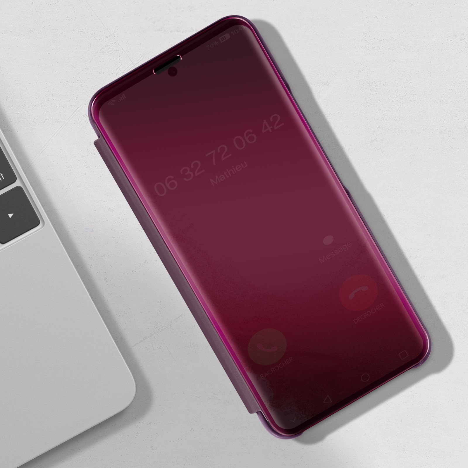 Uno schermo del telefono rosso mostra una chiamata da "Mathieu". Il telefono è su un tavolo.