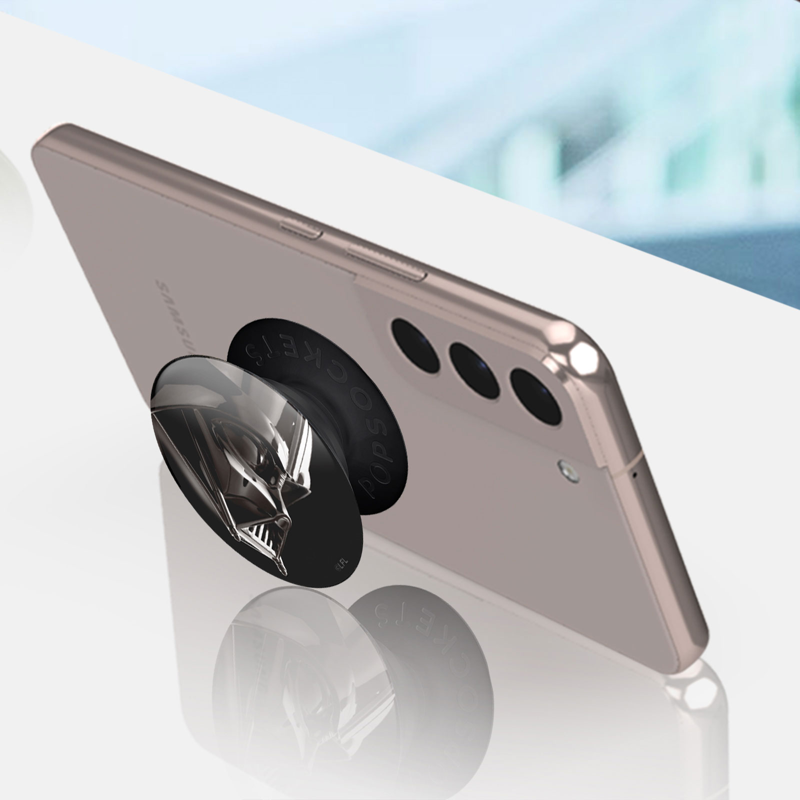 Smartphone mit Darth Vader PopSocket, auf weißer Oberfläche.