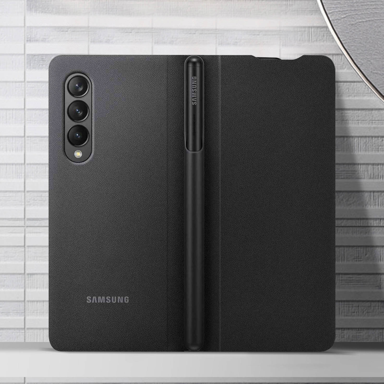 Schwarzes Telefon mit Stift und Hülle. Weiße Oberfläche.