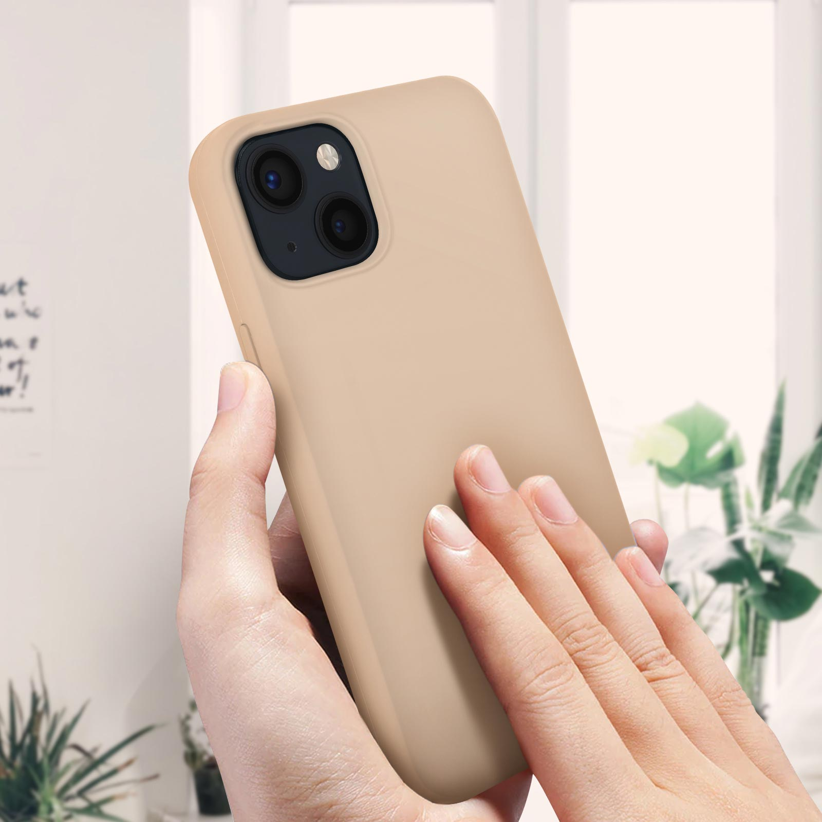 Custodia beige per telefono tenuta in una mano. Le lenti della fotocamera sono visibili.