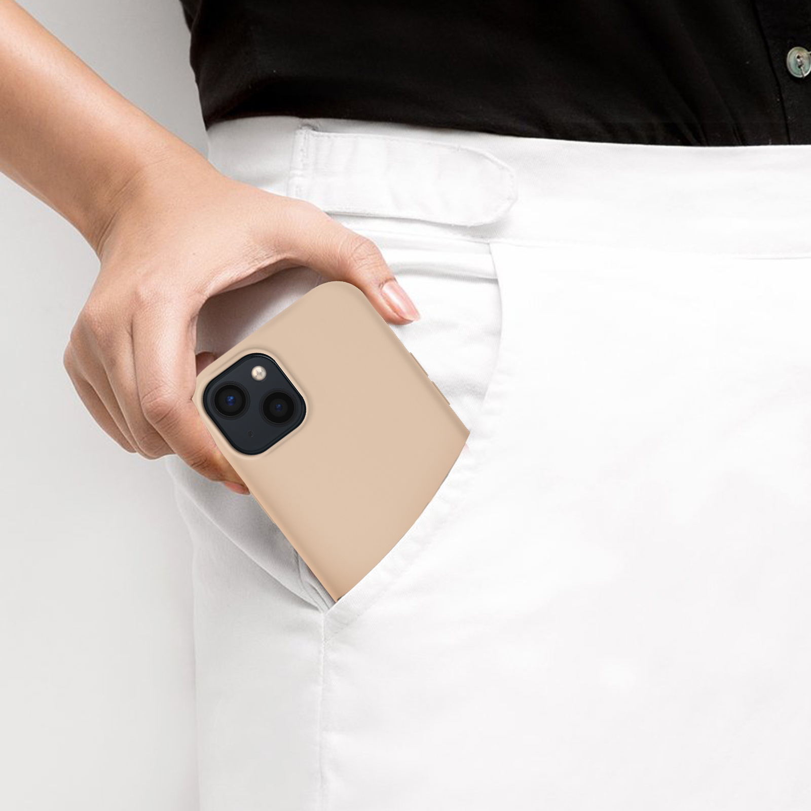 Una mano mette un telefono in una tasca bianca. Il telefono ha una custodia beige.