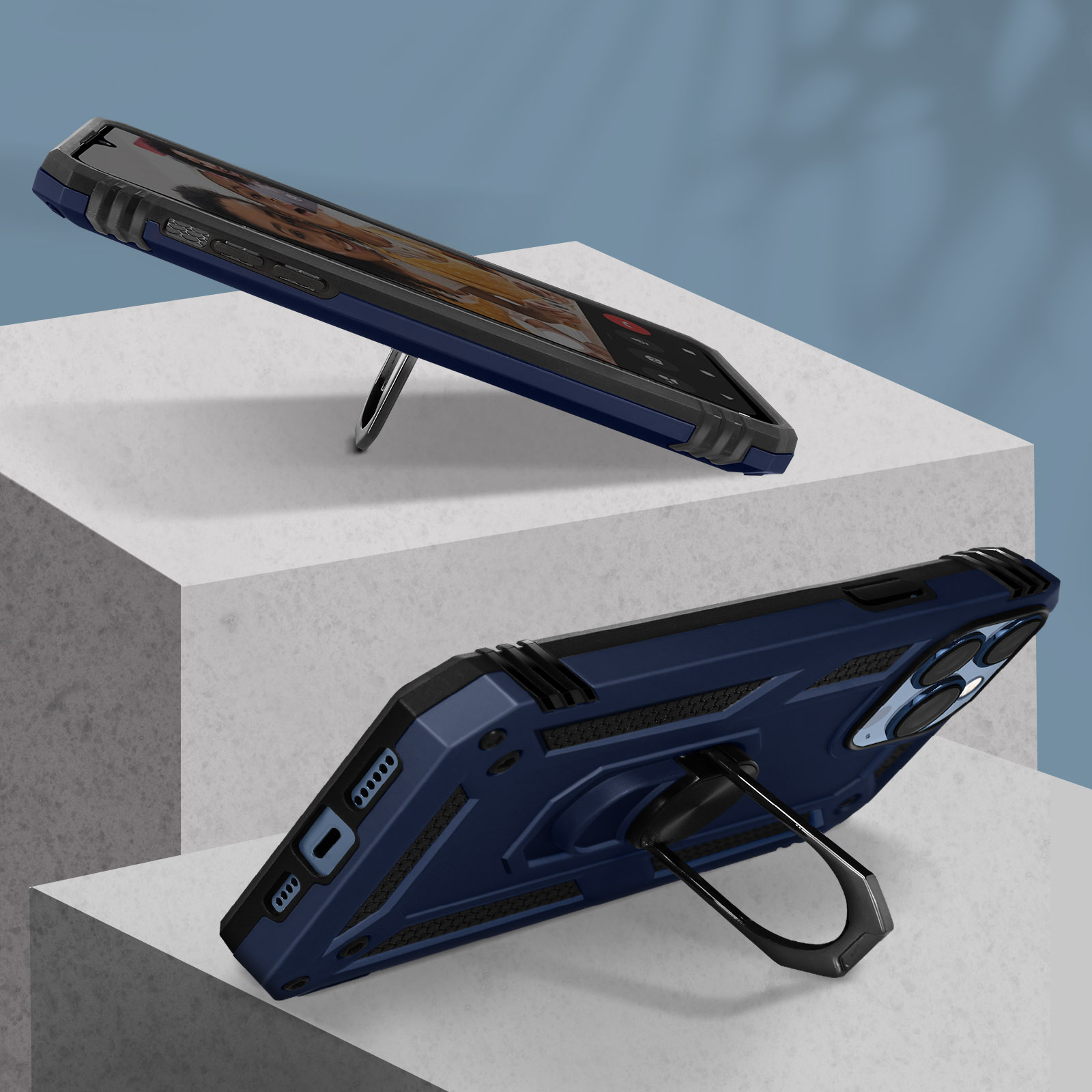 Twee hoeken van een blauwe telefoonhoes, met een ringstandaard, op een wit oppervlak.