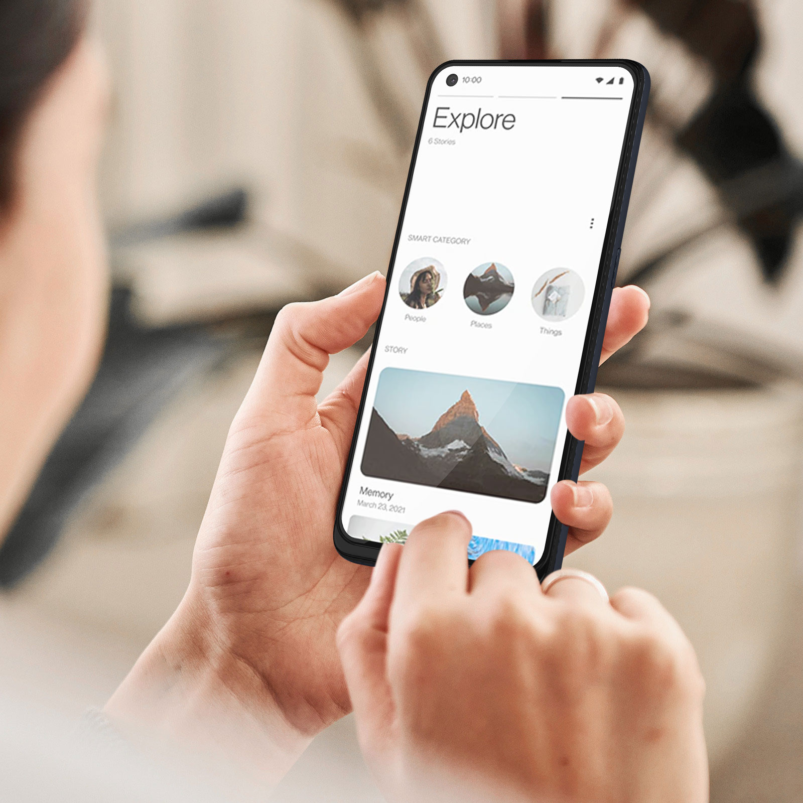 Una persona tiene in mano un telefono, esplorando un'app. Lo schermo mostra le opzioni dell'app, con un'immagine di montagna e testo.