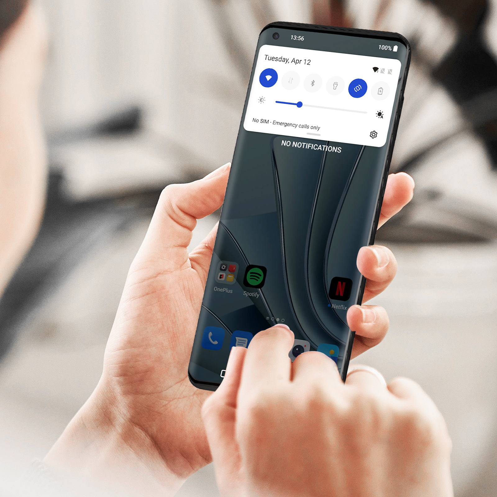 Mani di una persona che tiene un telefono che mostra la schermata iniziale con le app.