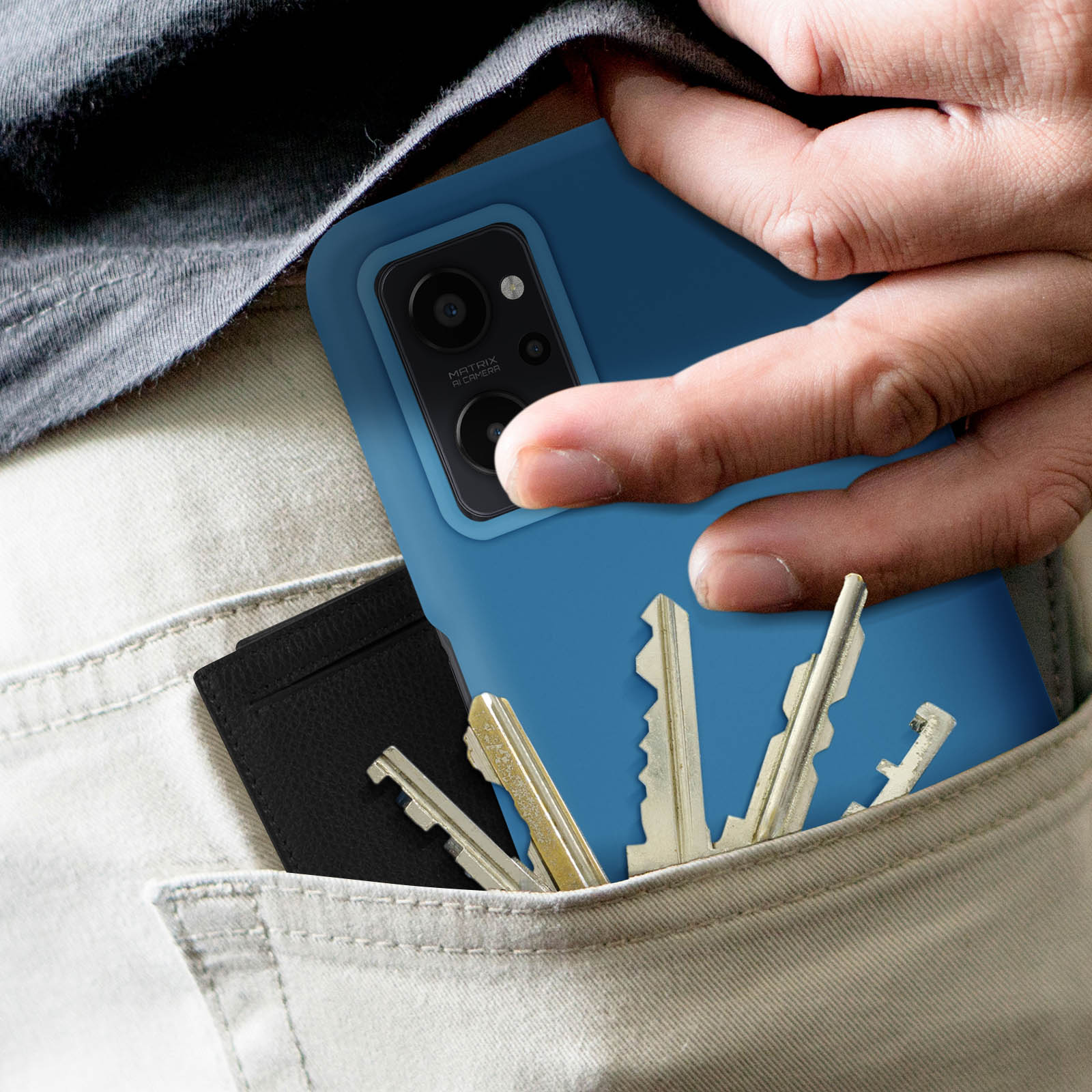Een hand die een blauwe telefoon in een zak houdt. Sleutels en een zwarte portemonnee zitten ook in de zak.