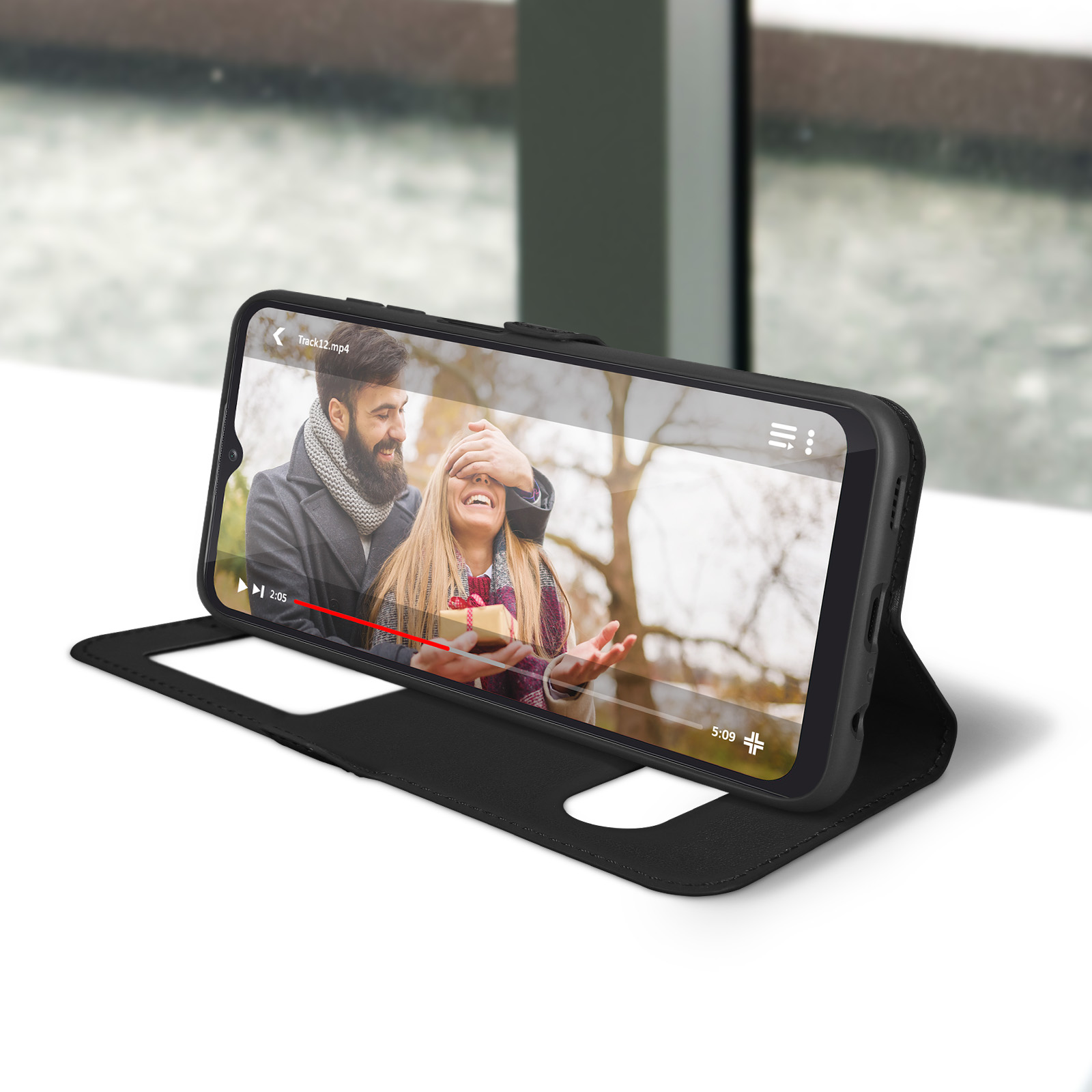 Un téléphone affiche une vidéo d'un couple, tenu dans une housse noire.