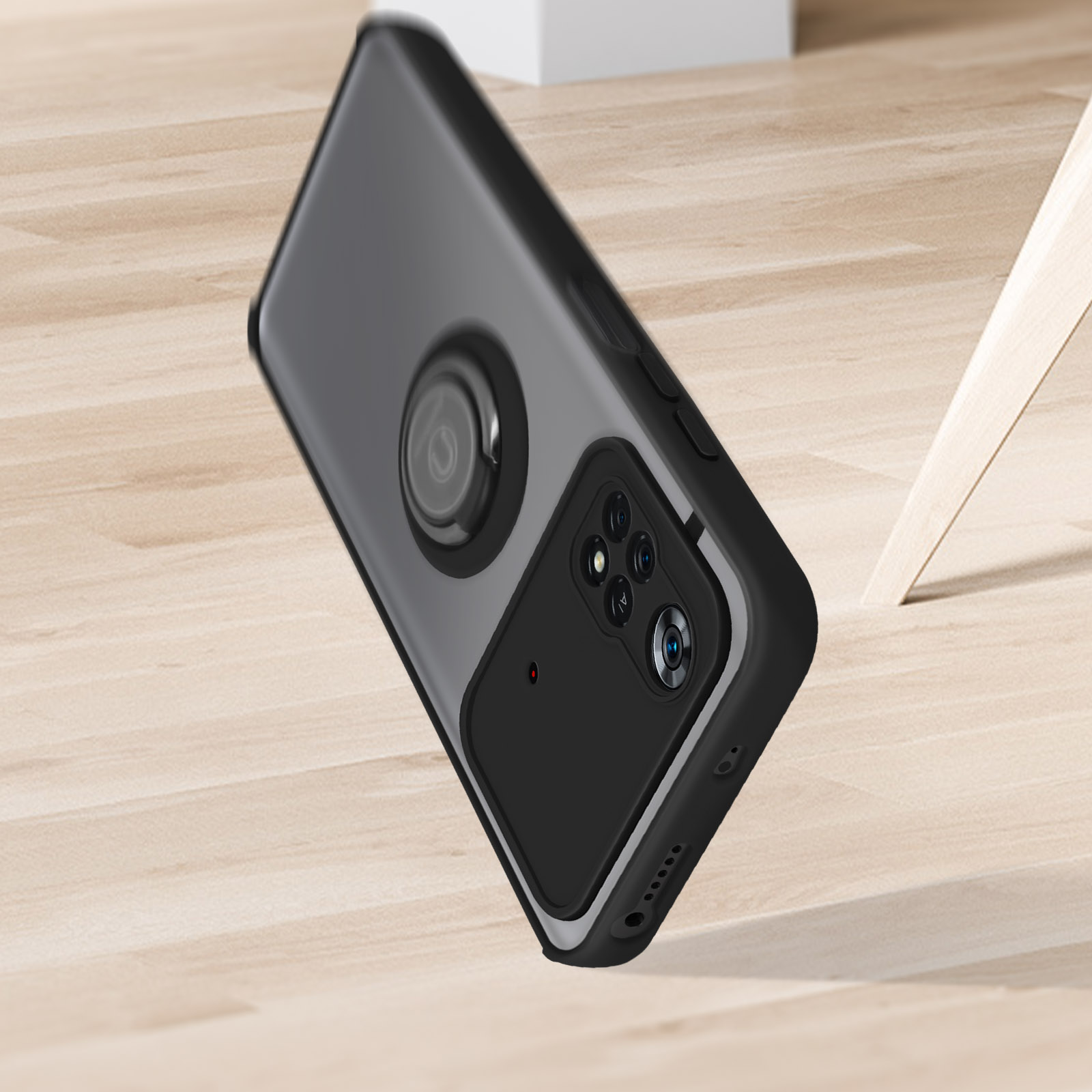 Un telefono con custodia nera e accessorio nero attaccato. Lo sfondo è un pavimento in legno chiaro.