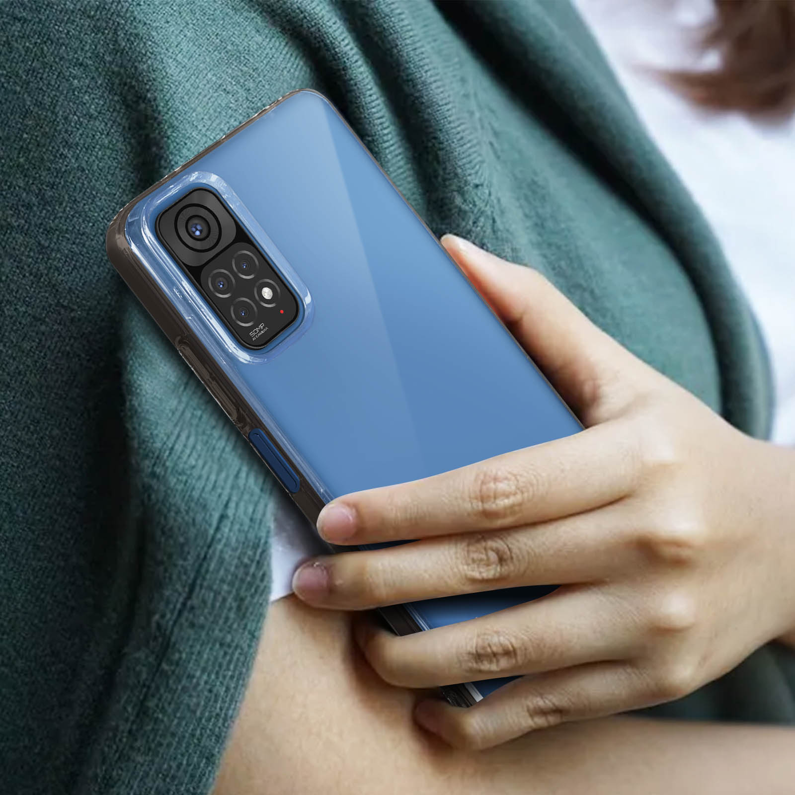 Una persona tiene in mano un telefono blu in una custodia. La custodia è trasparente sui lati. Il telefono è blu.