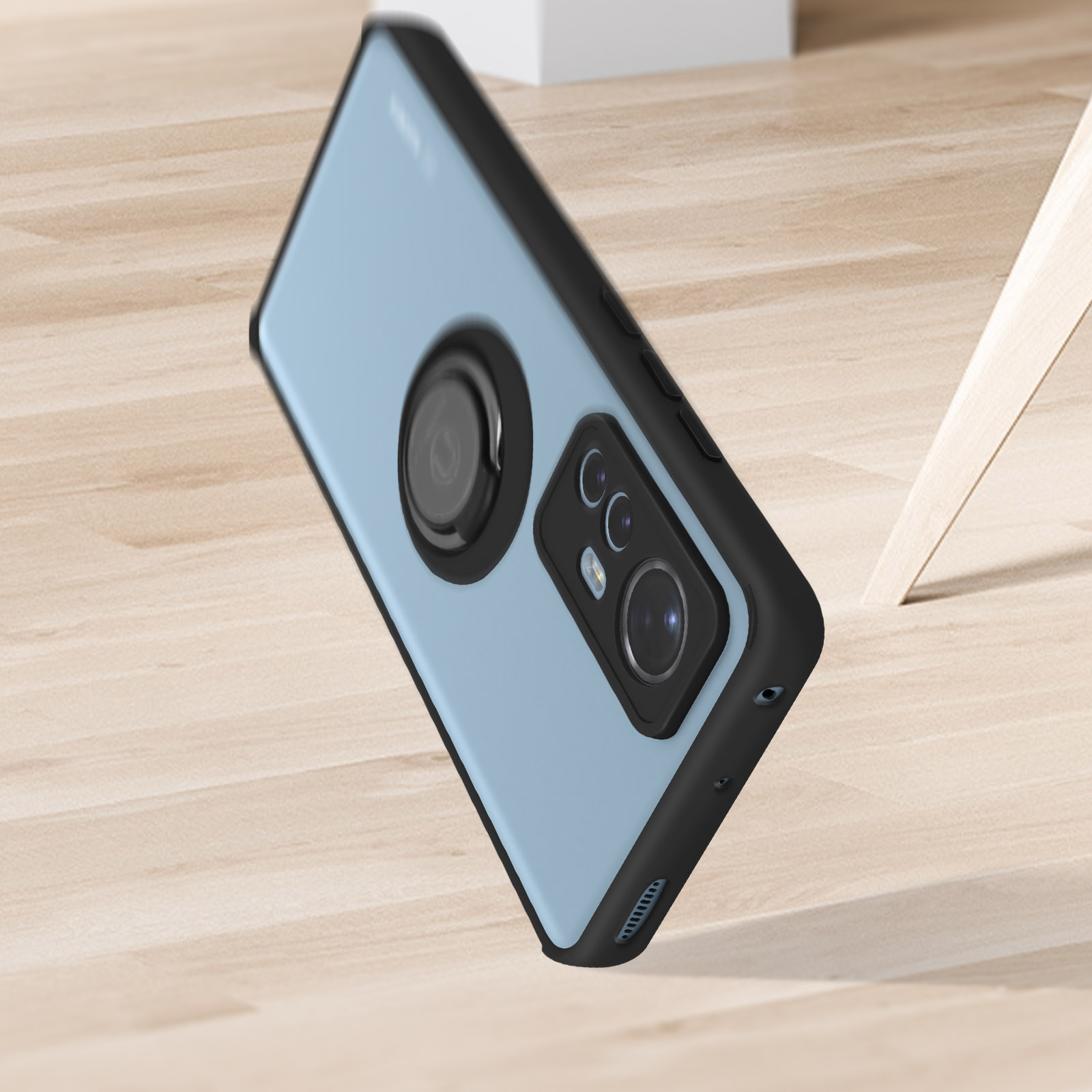 Custodia per telefono su una superficie in legno. La custodia è azzurra e nera, con un anello per la fotocamera.