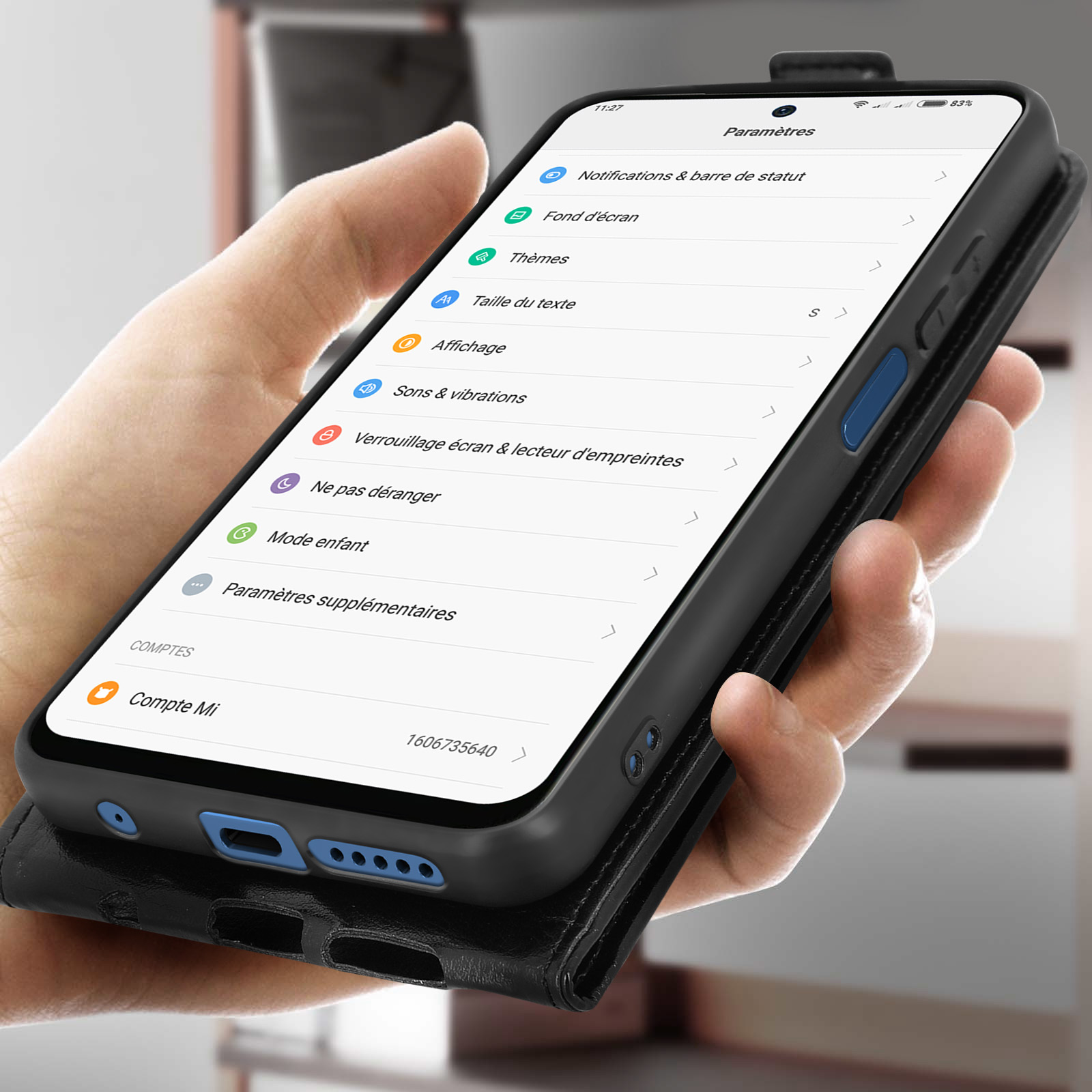 Un telefono in una custodia nera mostra le impostazioni. Il telefono è tenuto in mano.
