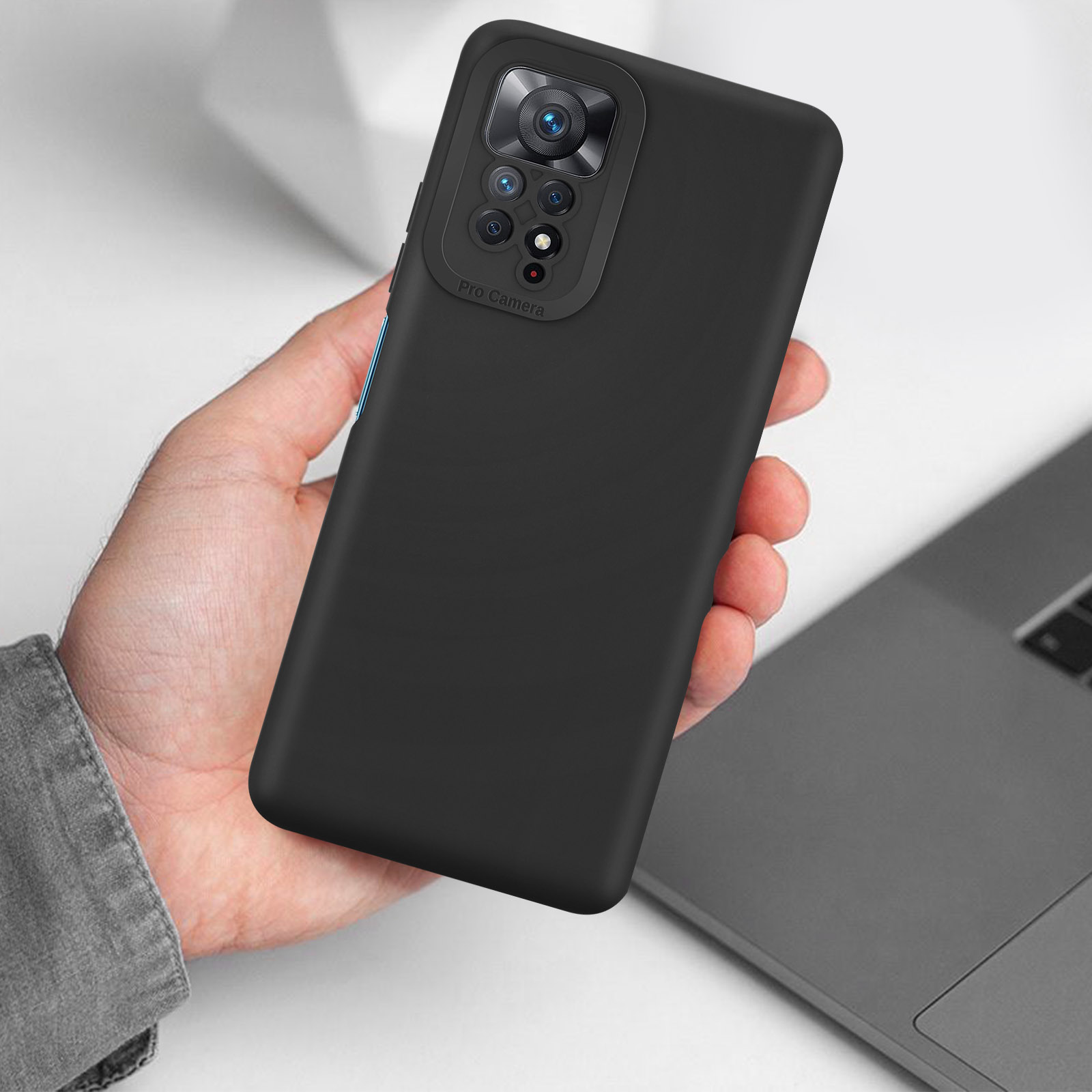 Étui de téléphone noir. Une main le tient. Fond gris. Ordinateur portable en arrière-plan.