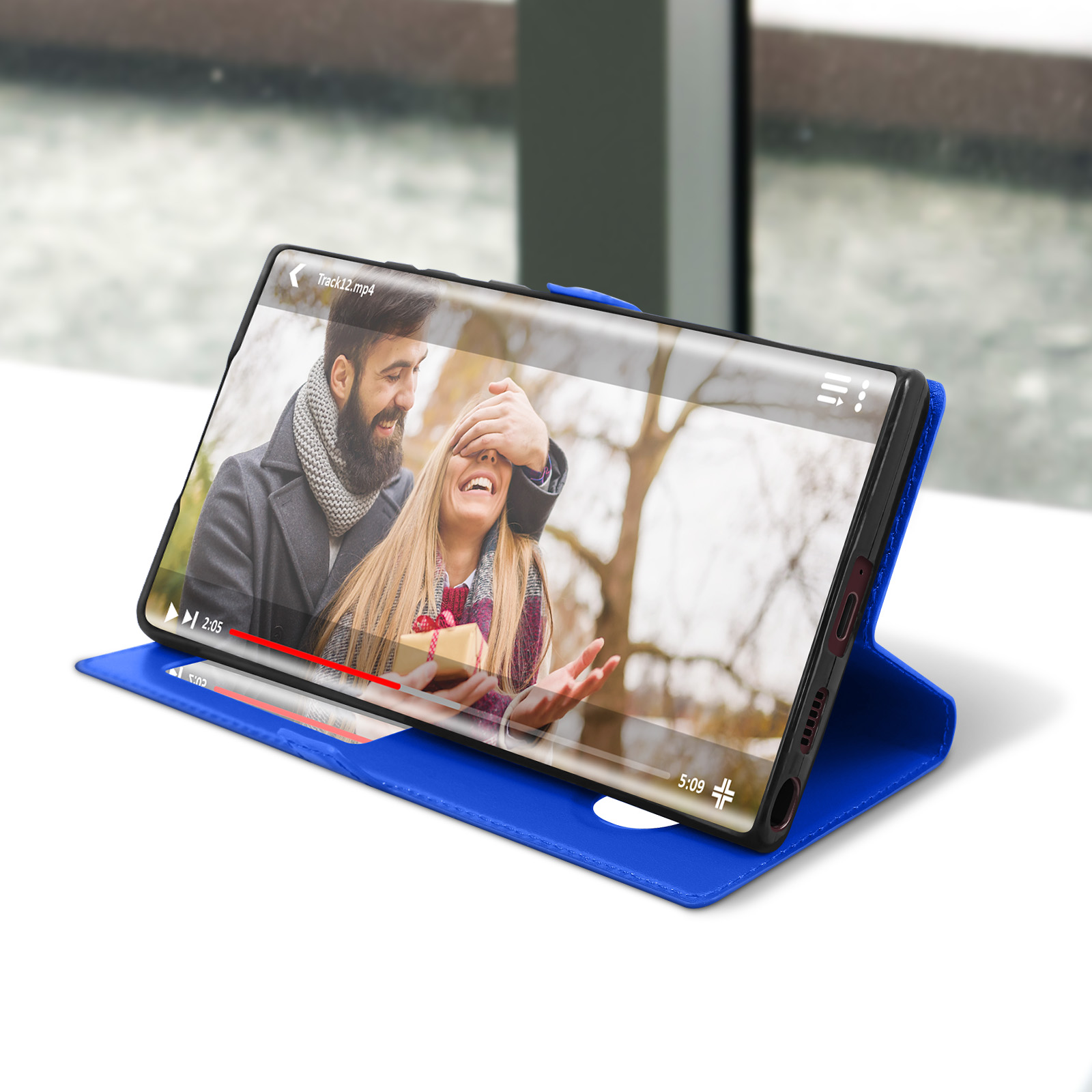 Coque de téléphone bleue avec une vidéo en cours de lecture sur l'écran d'un téléphone. Un couple s'embrasse.