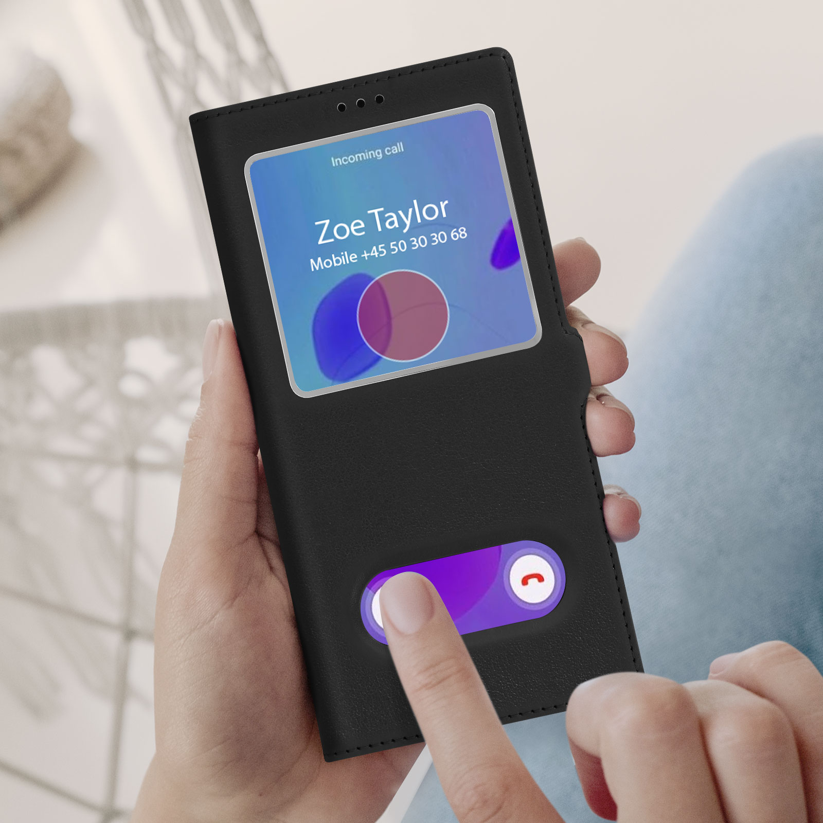 Une main tient un téléphone noir. L'écran affiche un appel entrant de Zoe Taylor.