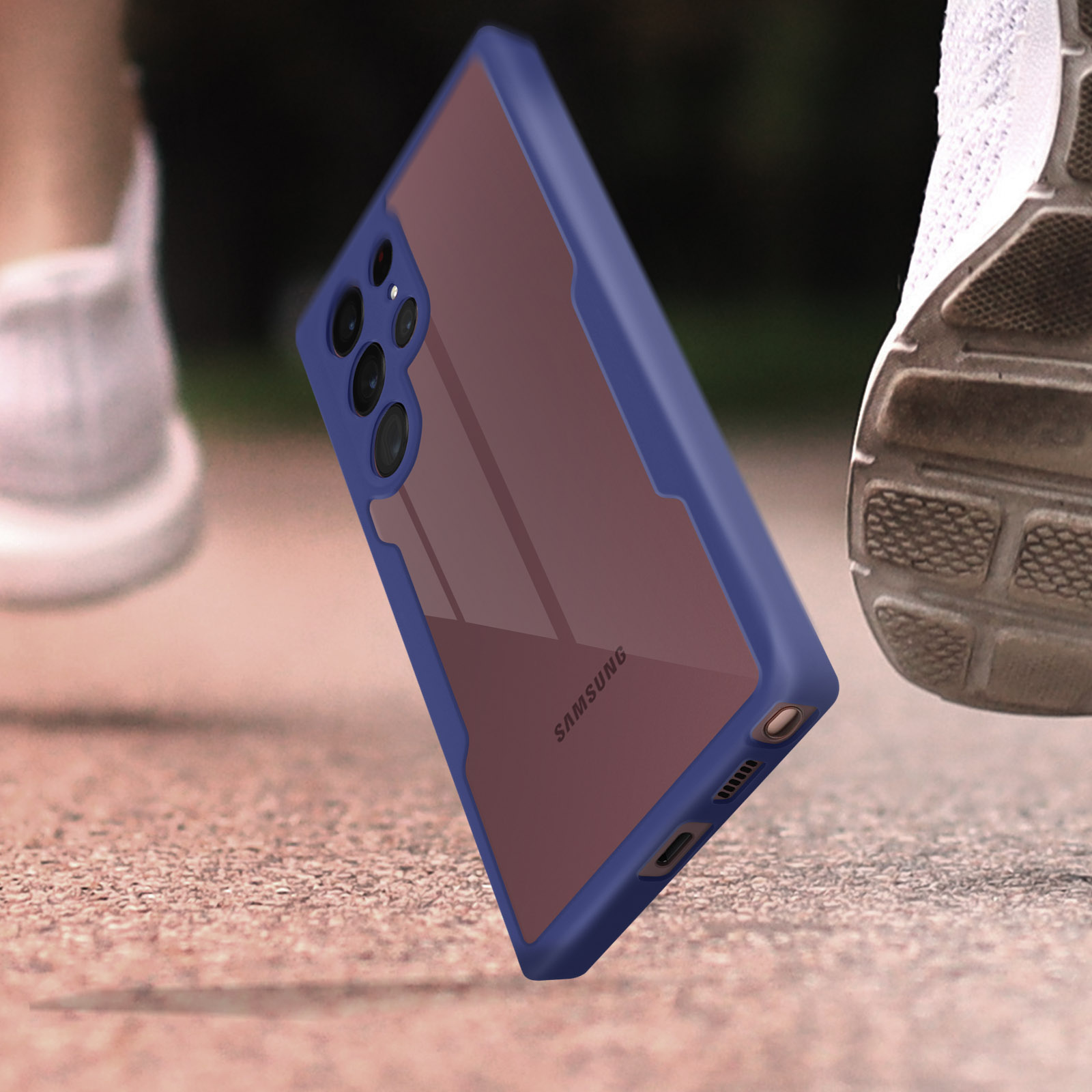 Custodia per telefono, cornice blu, retro trasparente con motivo marrone. Logo Samsung visibile. Sfondo sfocato con scarpe da corsa.