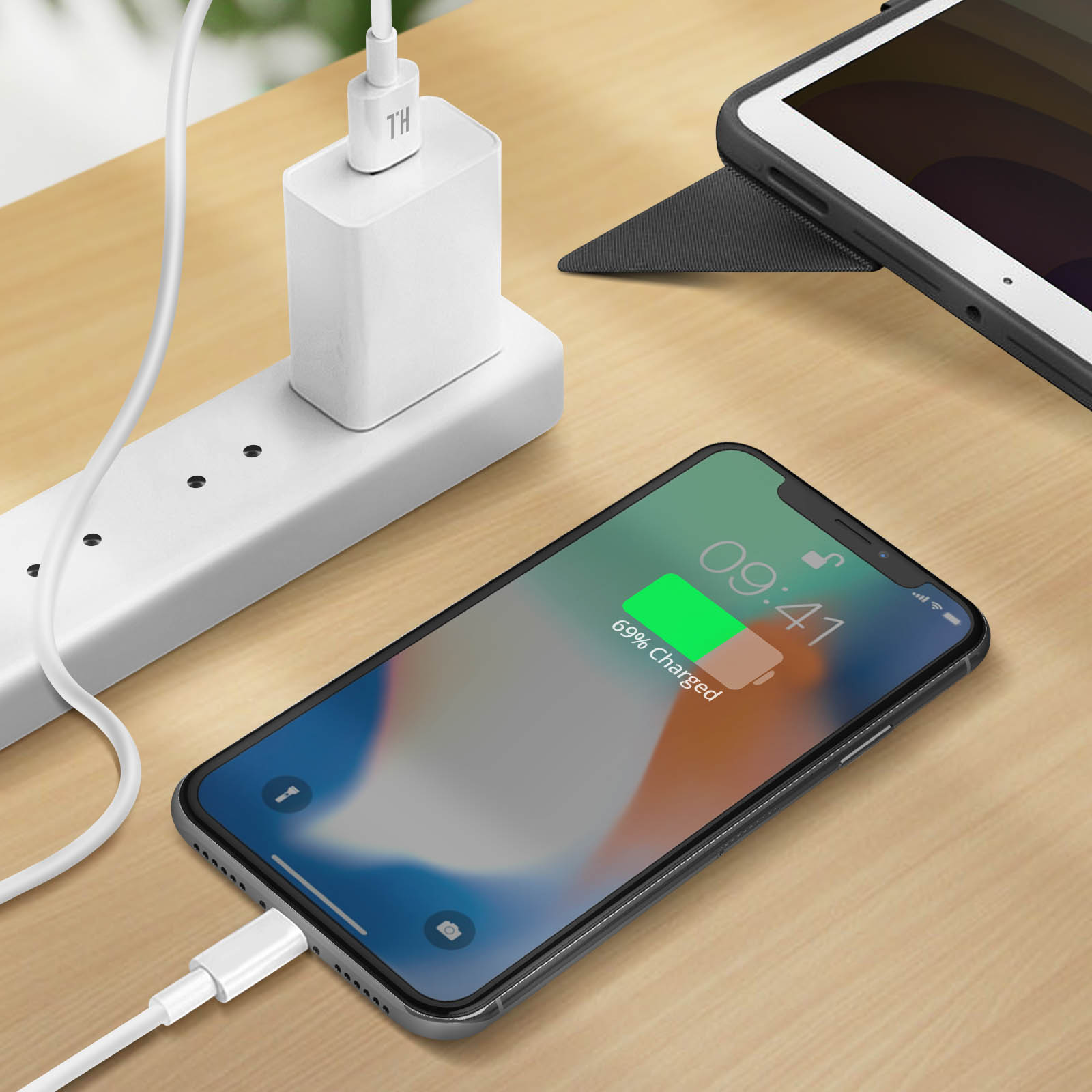 Telefon und Tablet laden. Weißer Stecker. Holztisch.