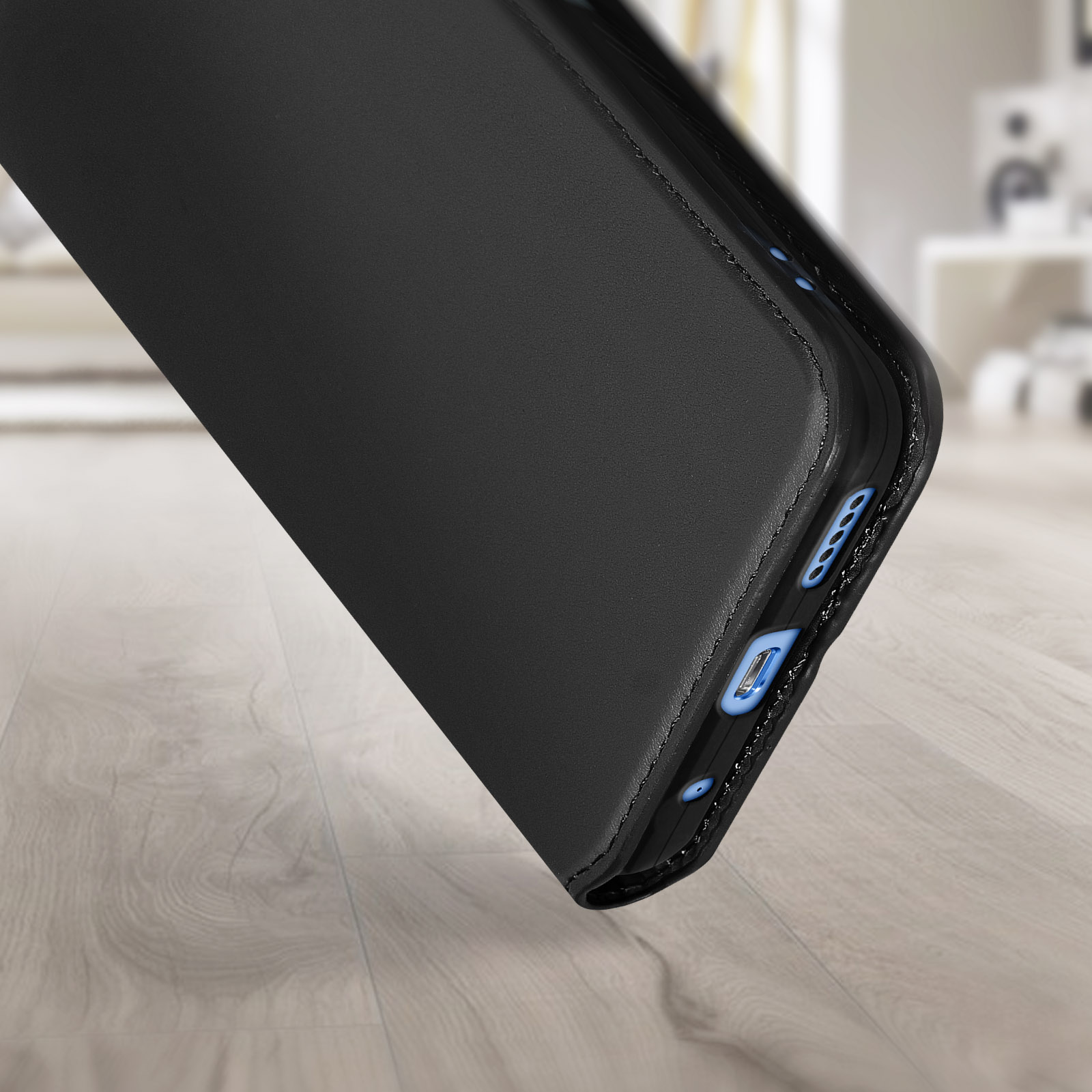 Coque de téléphone en cuir noir avec une finition brillante. L'étui est légèrement ouvert, montrant le téléphone à l'intérieur.