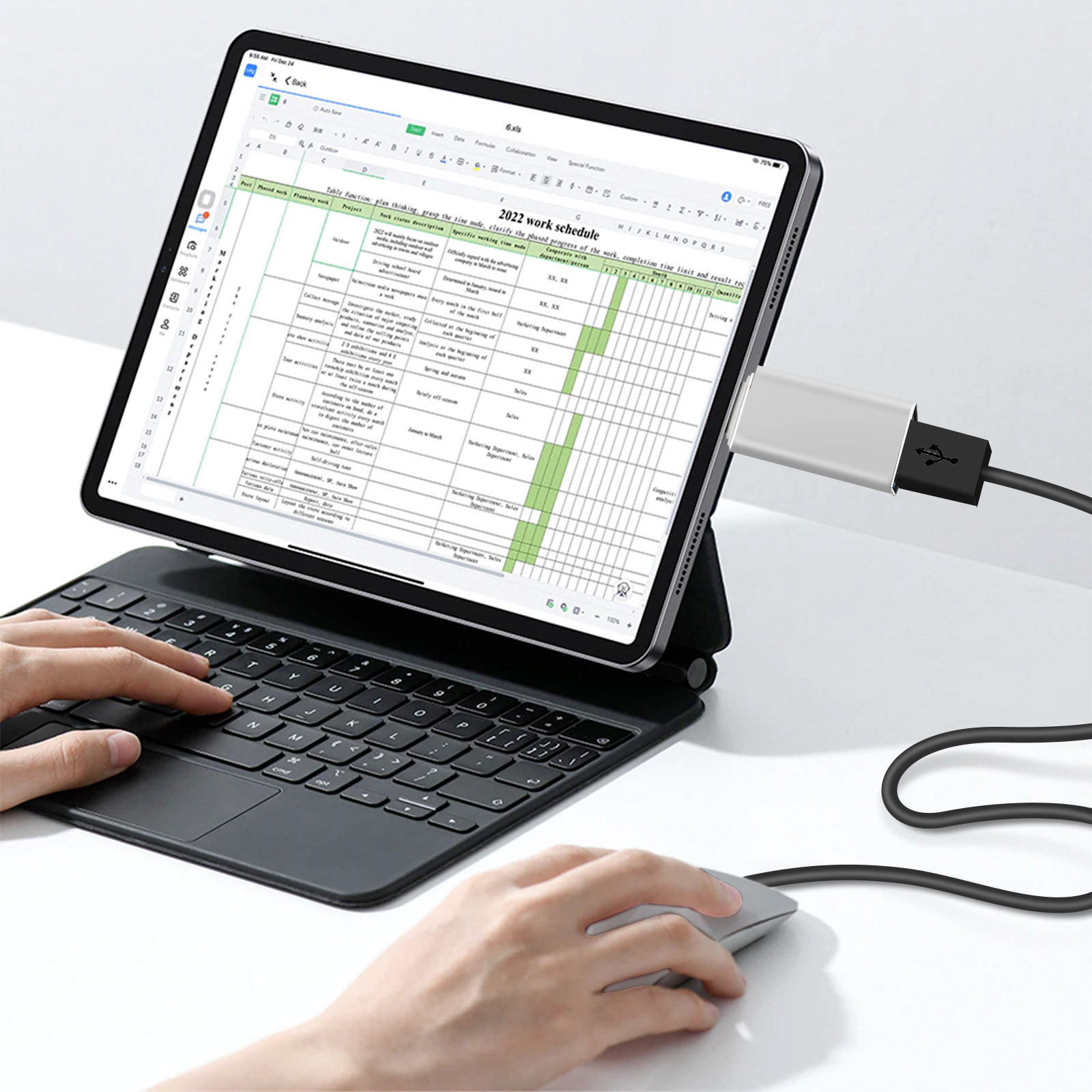 Tablet con tastiera e mouse, mostra un programma di lavoro. Una mano usa il mouse.