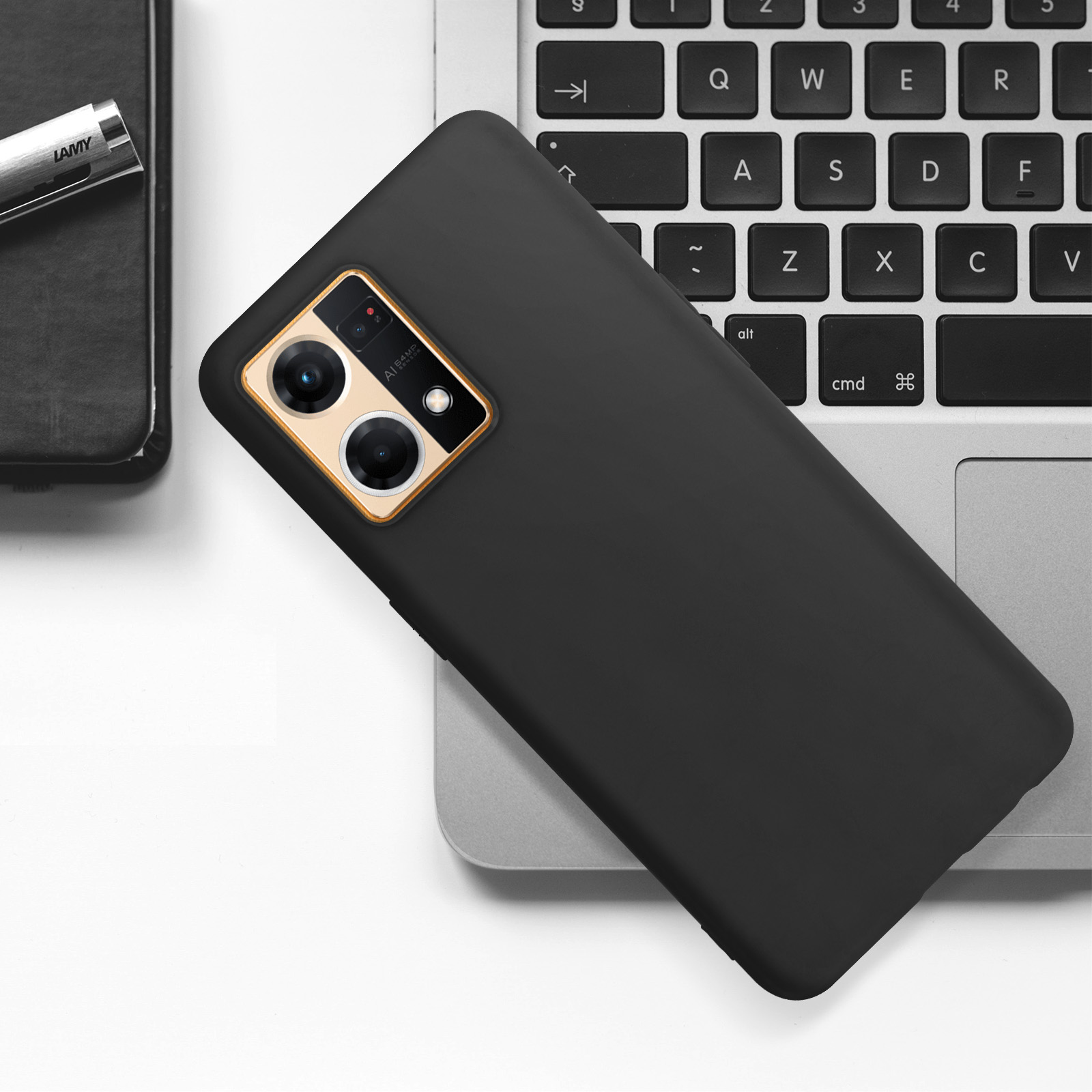 Una custodia nera per telefono su una tastiera di un laptop. Una penna è a sinistra. L'area della fotocamera ha un bordo dorato.