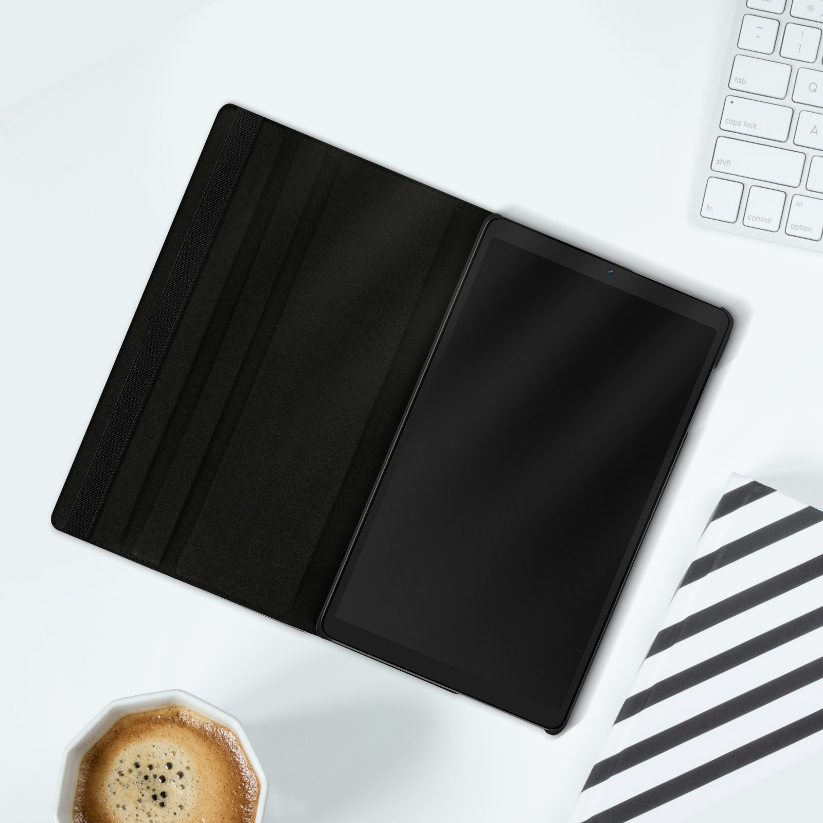 Tablet in custodia nera, aperto su superficie bianca, vicino tastiera.