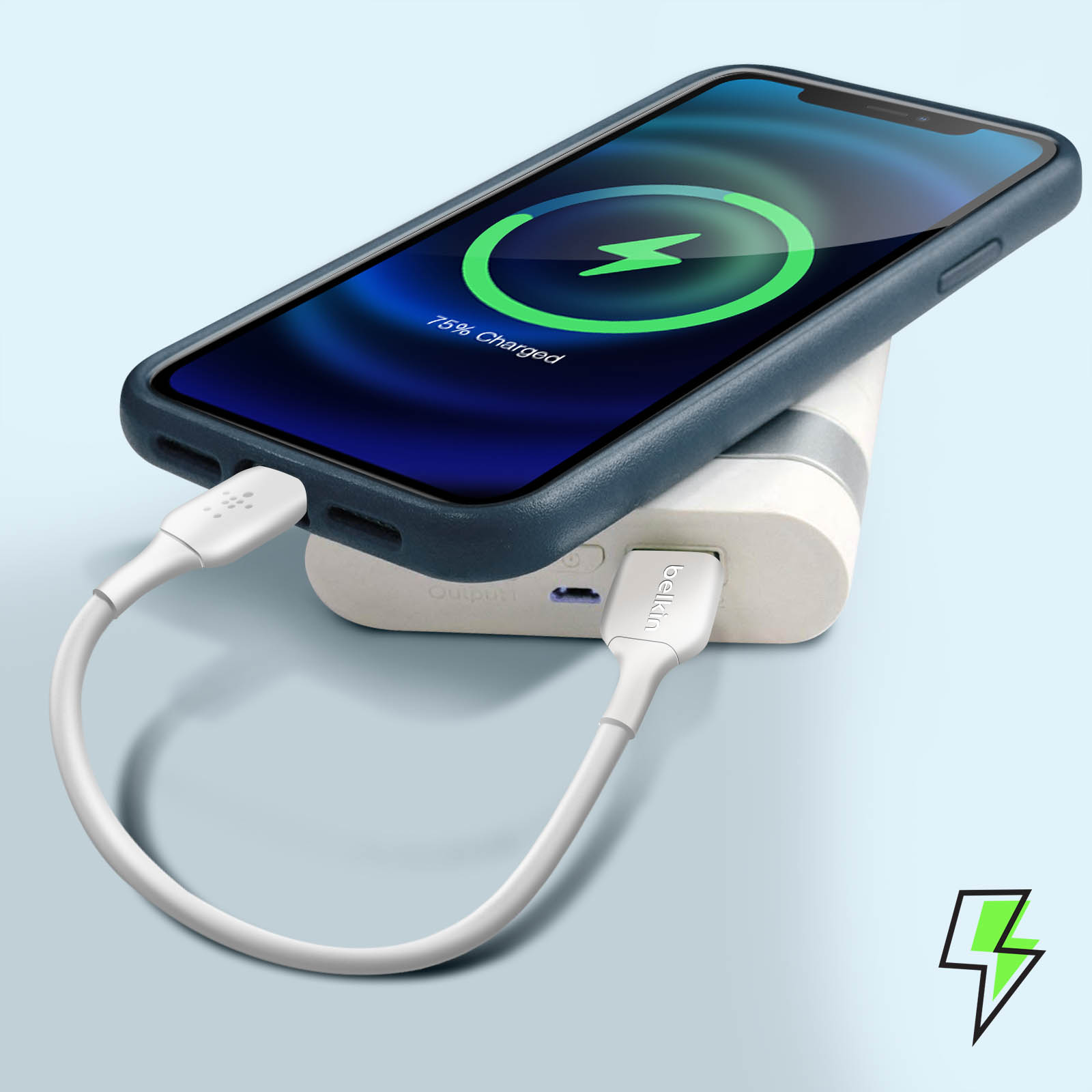 Telefono in carica su un power bank. Il telefono ha una custodia blu e mostra la carica. Fulmine verde.