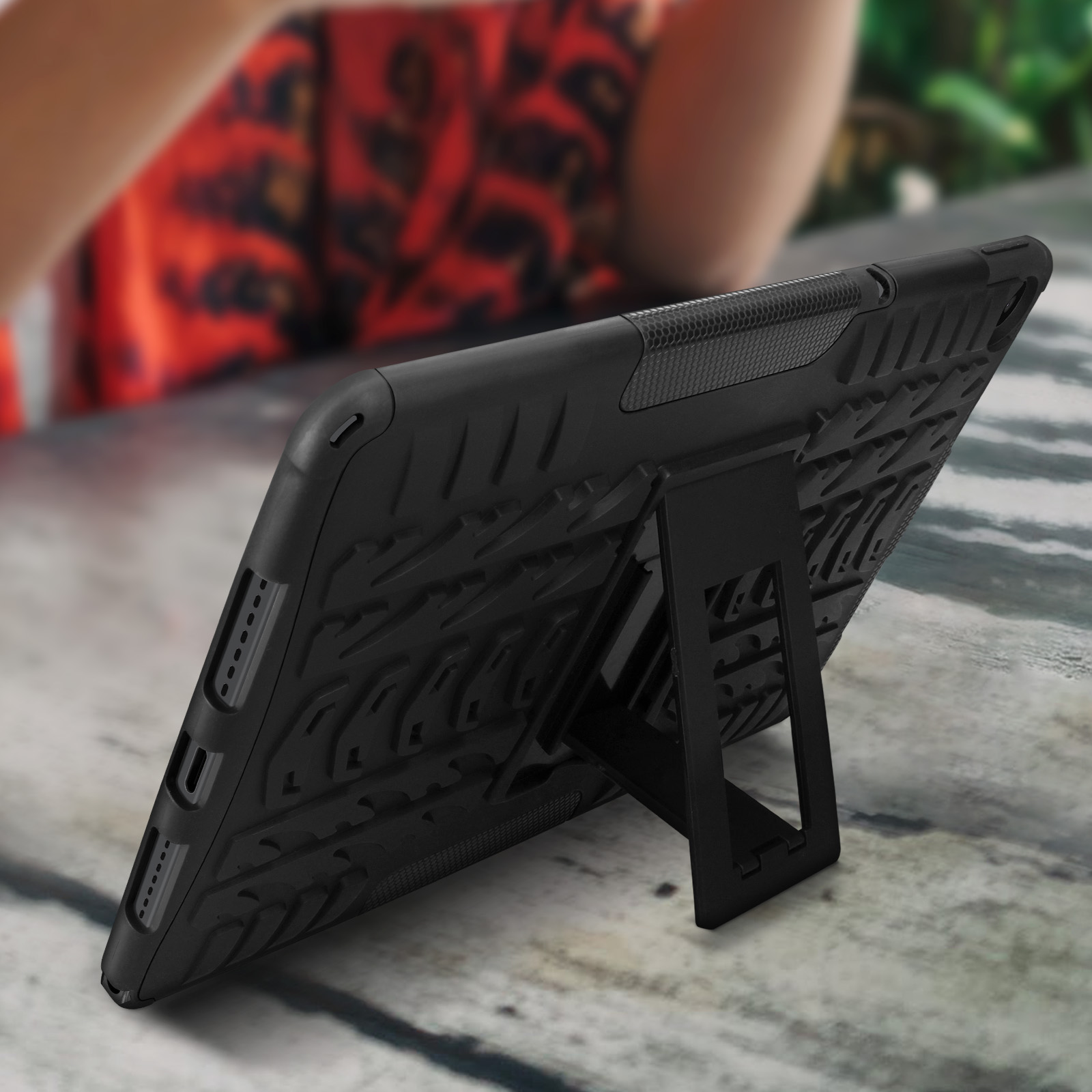 Schwarze Tablet-Hülle mit Ständer. Hülle ist strukturiert, ruht auf Holzoberfläche.