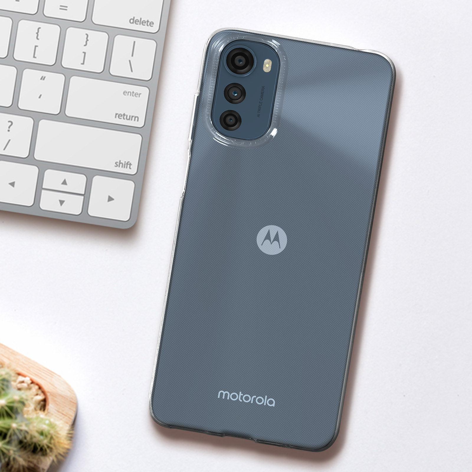 Custodia trasparente per telefono Motorola su un tavolo bianco con tastiera sullo sfondo.