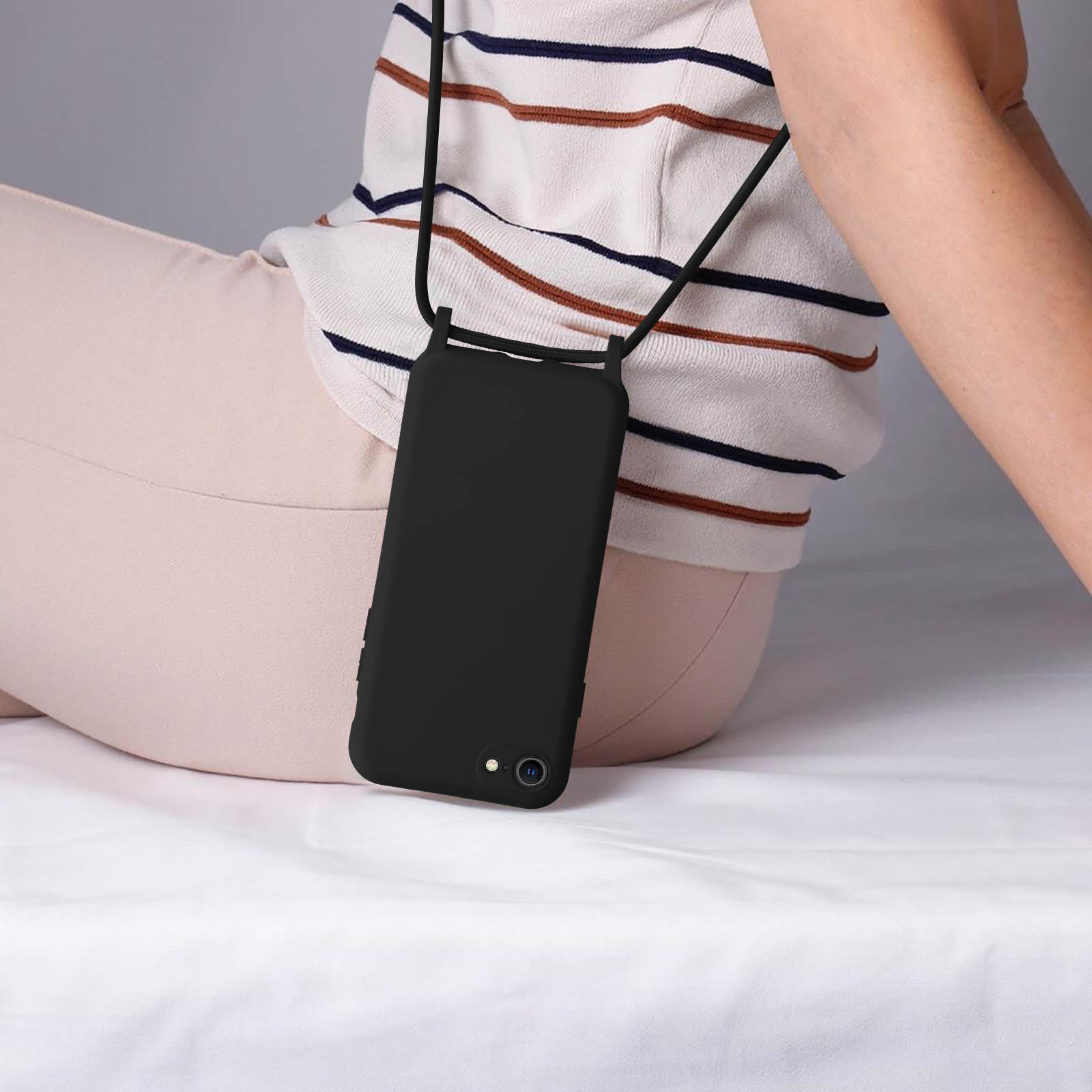 Une personne portant un étui de téléphone noir avec un cordon autour du cou.